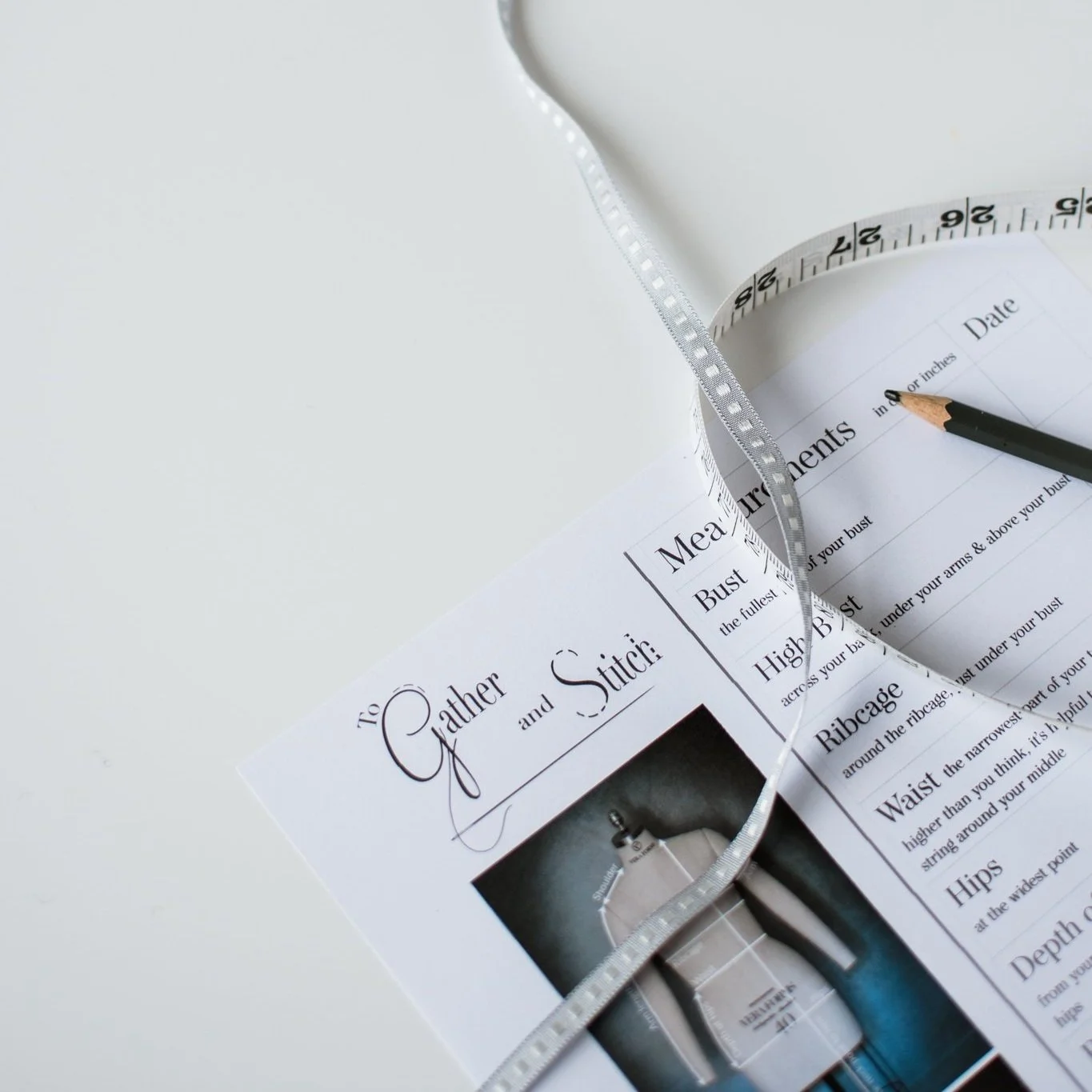 A measurement chart, tape measure and a pencil