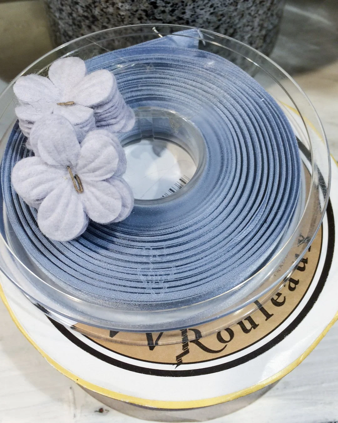 Rolls of blue ribbon and fabric flowers from VV Rouleaux