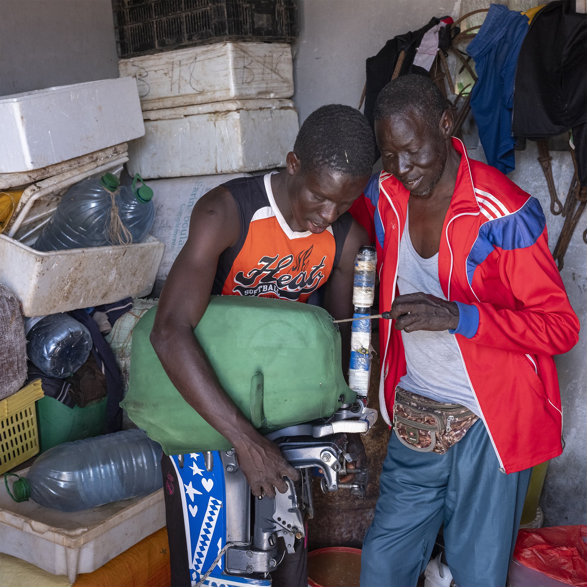 FATHER AND SON -
Lébou fisherman Issa Diagne teaches his son how to operate and maintain an outboard motor. Since time immemorial, navigation and fishing skills were transmitted from one generation to the next