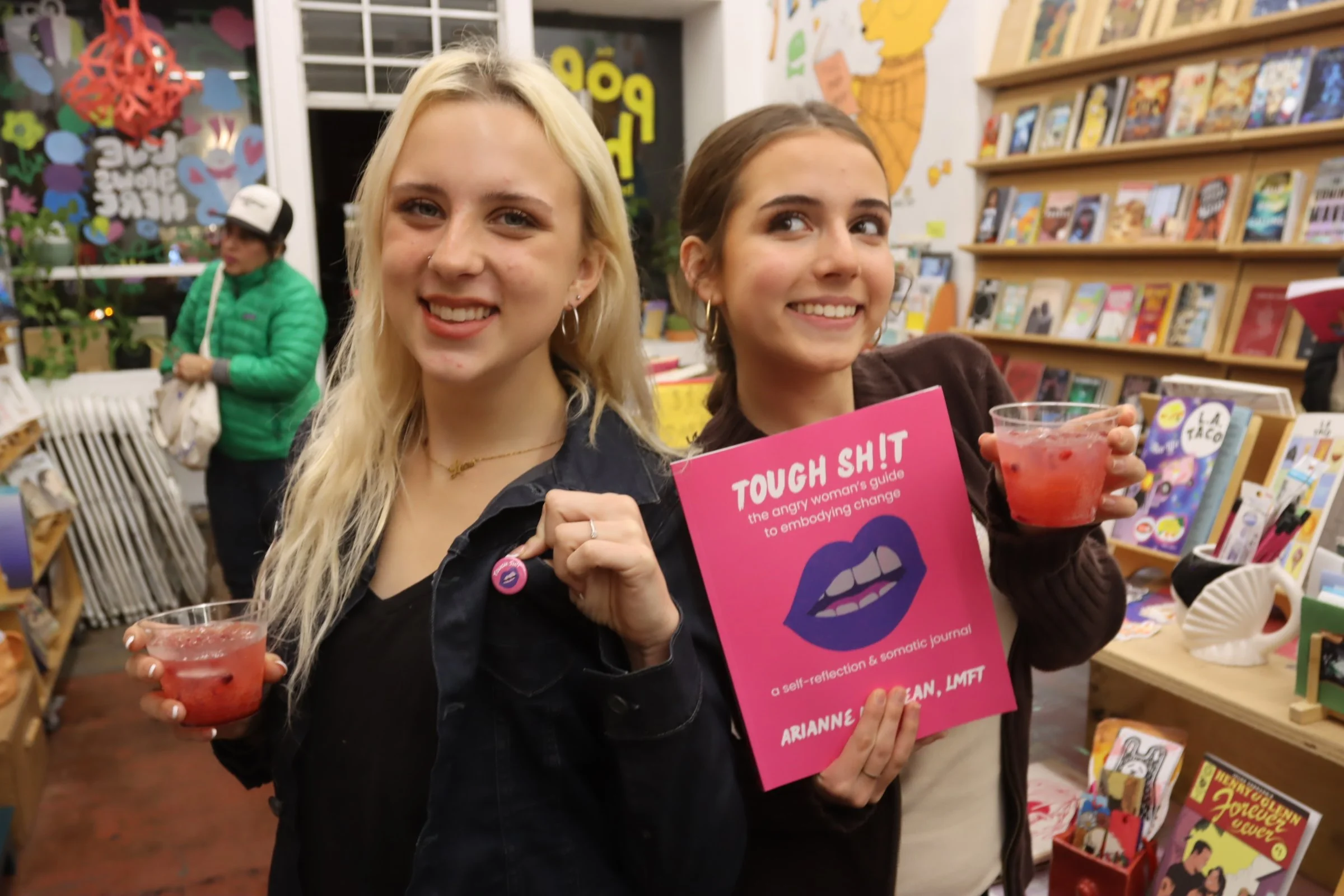 Young girls posing with Tough Shit Book and pin