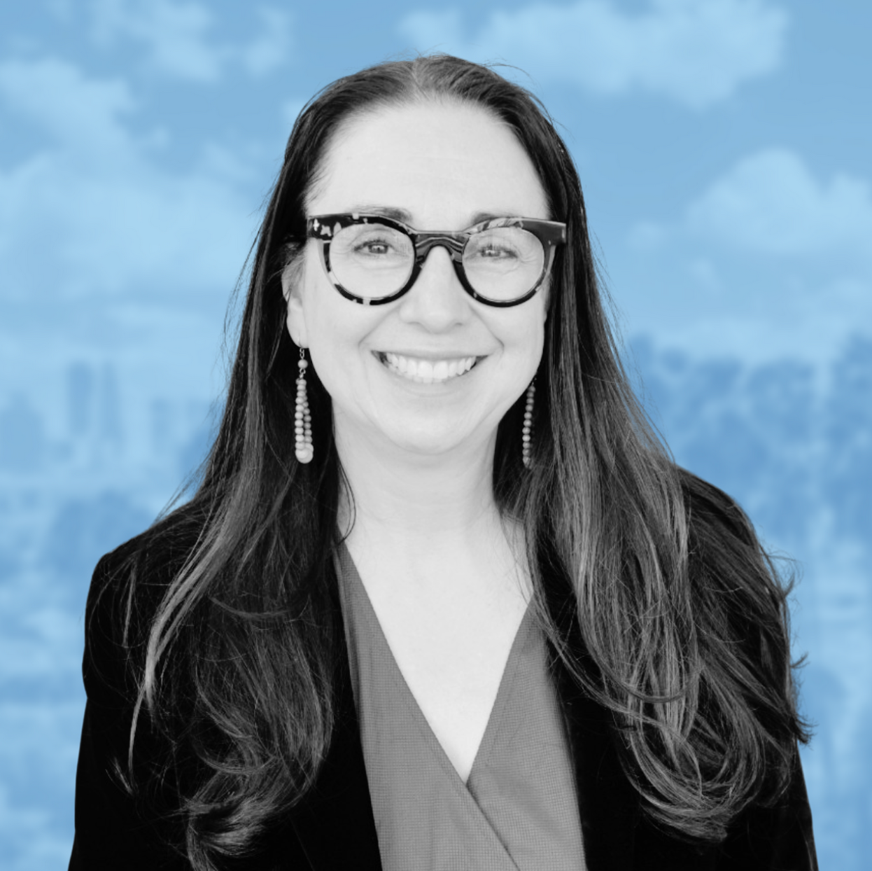 Headshot of Tiffany Hogan, long dark hair, tortoise shell glasses, big bright smile