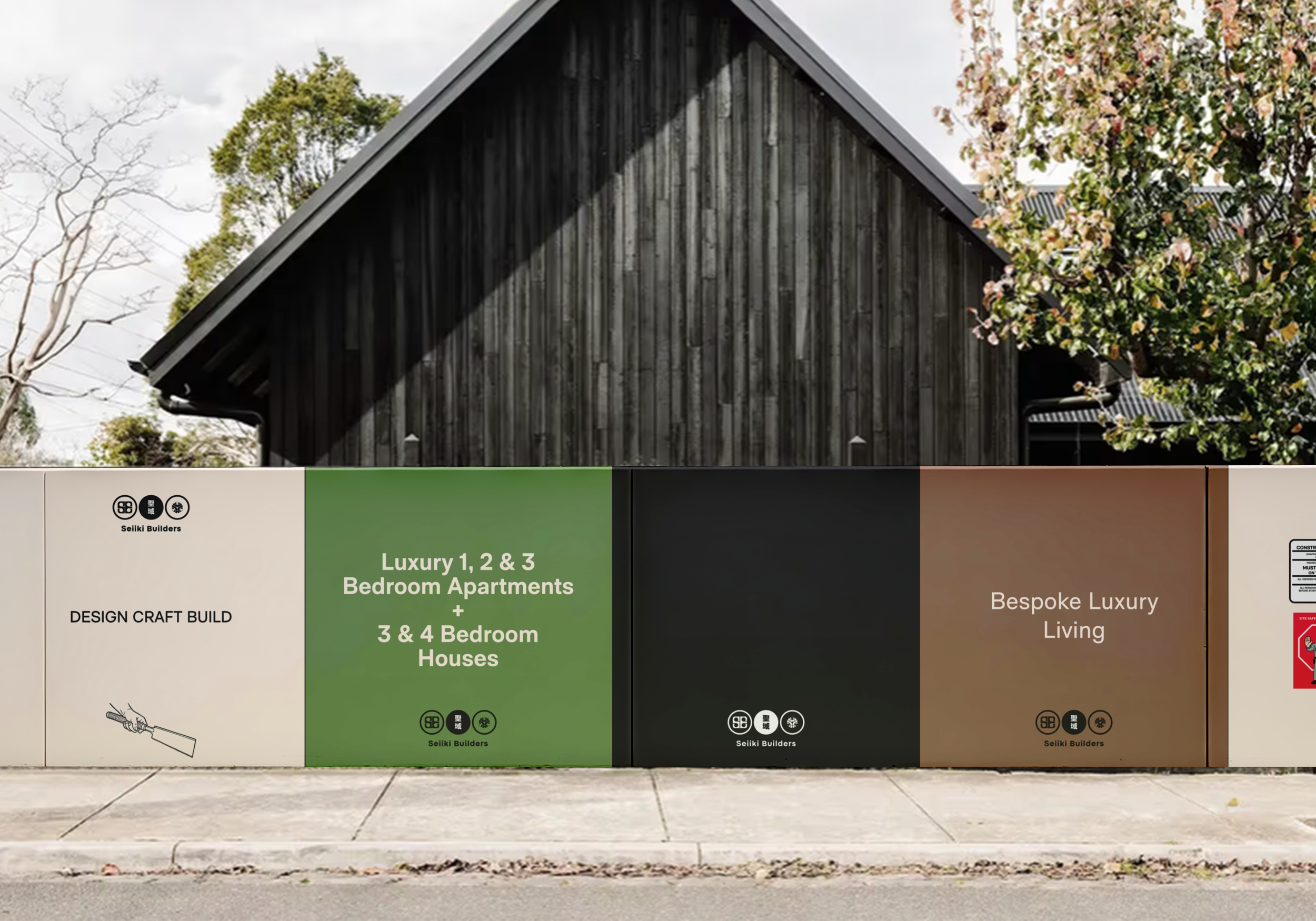A band of construction panels in front of a dark wooden building with trees and a partly cloudy sky. The panels display advertisements for luxury apartments and houses by Seiki Builders.