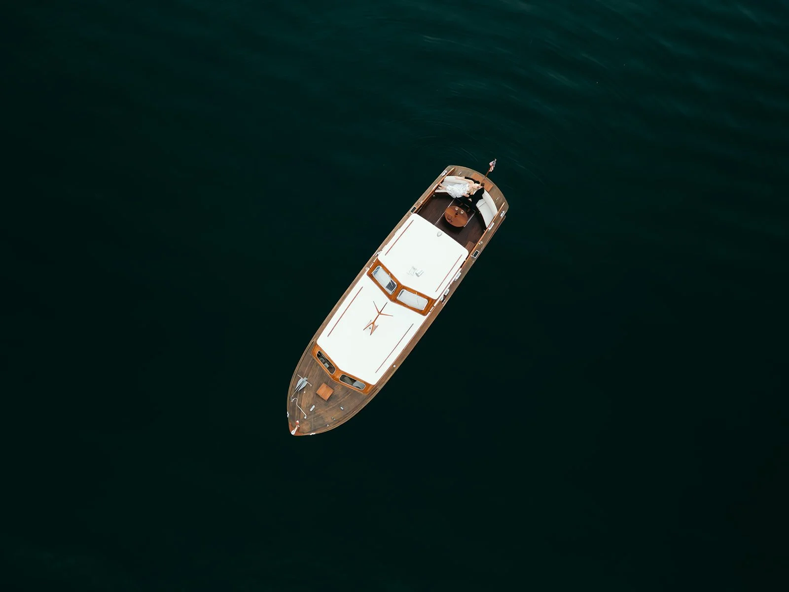 Aerial view of a yacht floating on dark water.