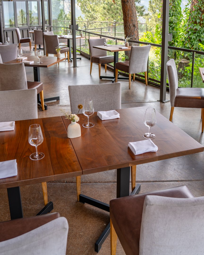 Connected walnut restaurant tables on patio at Flagstaff House