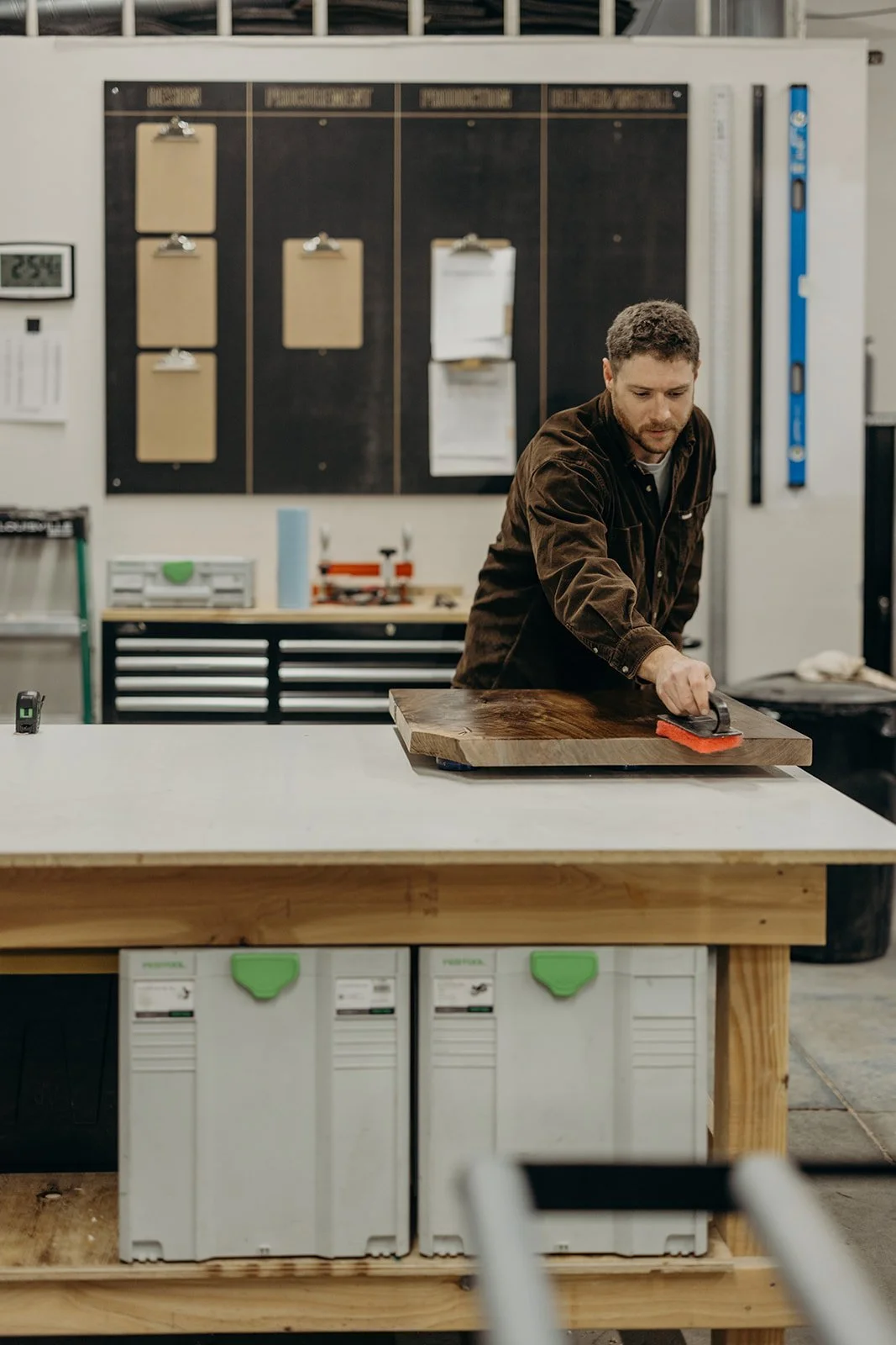 Dust & Spark founder applying oil finish to a figured walnut table top