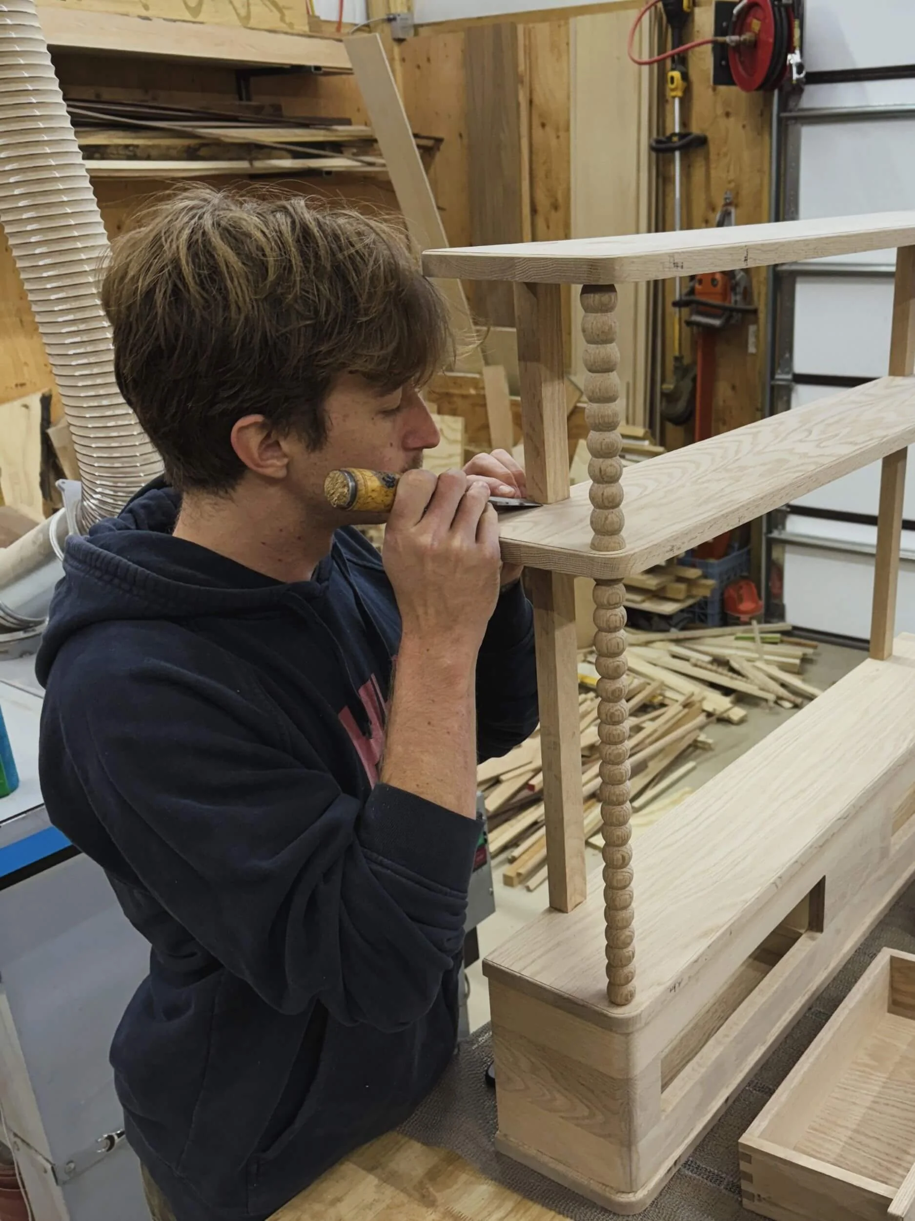 Dust & Spark craftsman using a chisel to clean up a wood joint