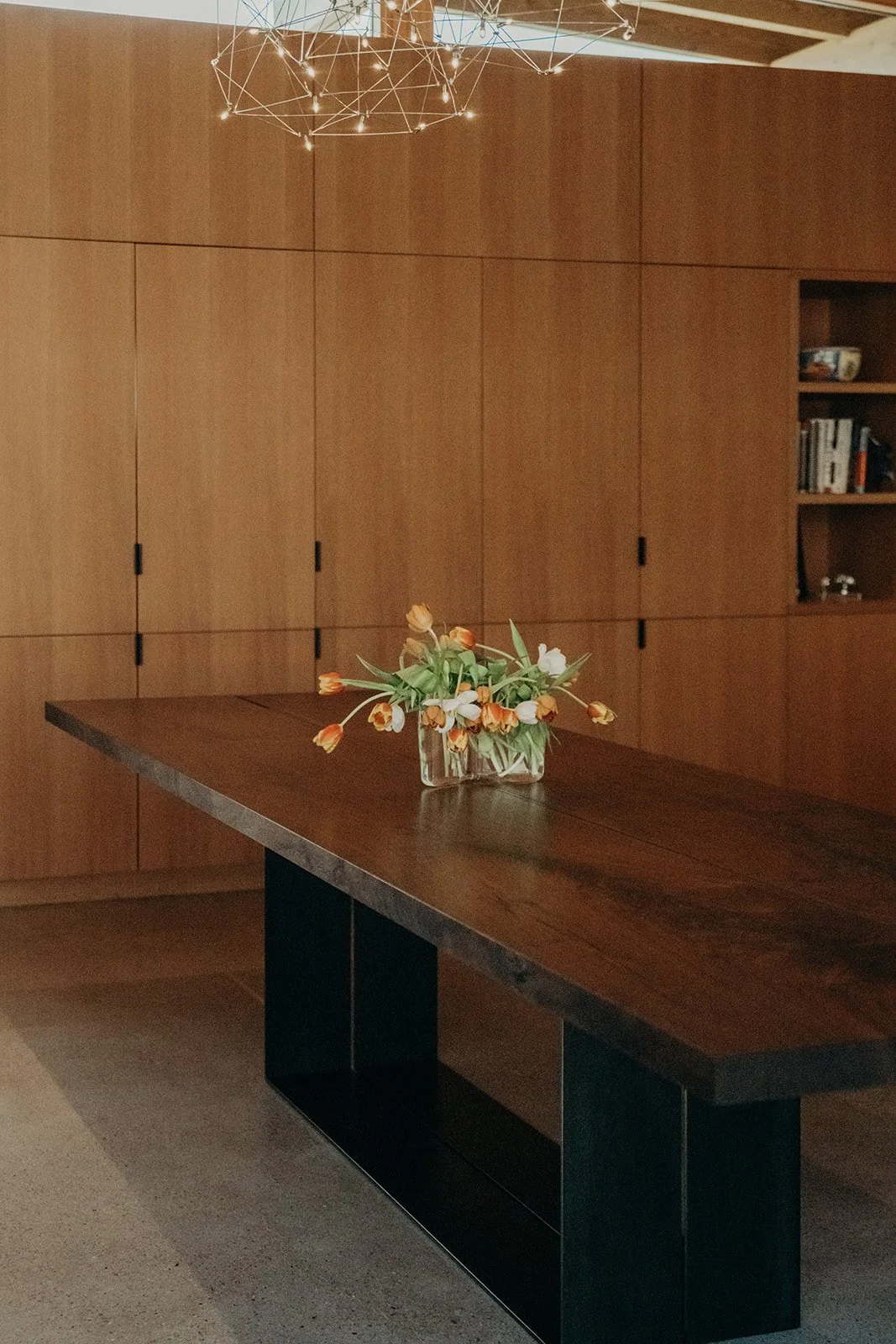 Custom walnut dining table with blackened steel base