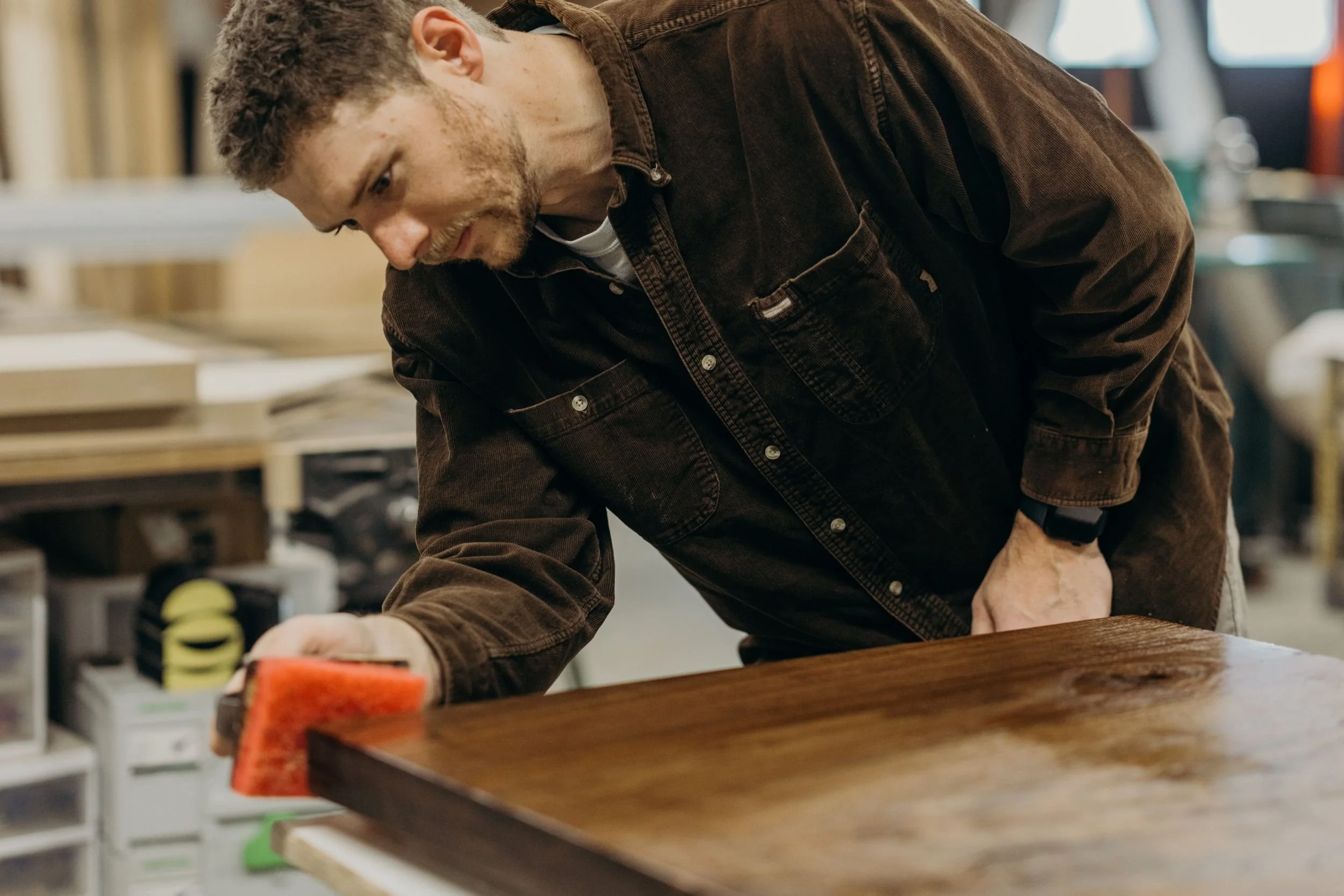 Dust & Spark founder, Scott Hensen, applying oil finish to small walnut table top