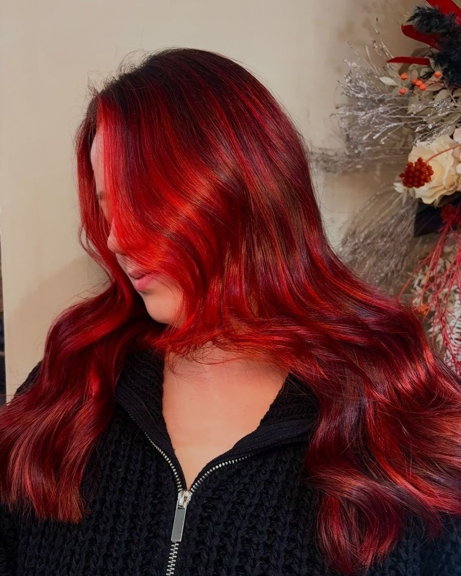 From grown-out colour and box dye history ➡️ to bold, fiery red perfection 💋🔥

Madison transformed this hair with a vibrant red balayage and a seamless black root melt for depth and drama. Created using @wellahair Color Fresh Create Next Red for th