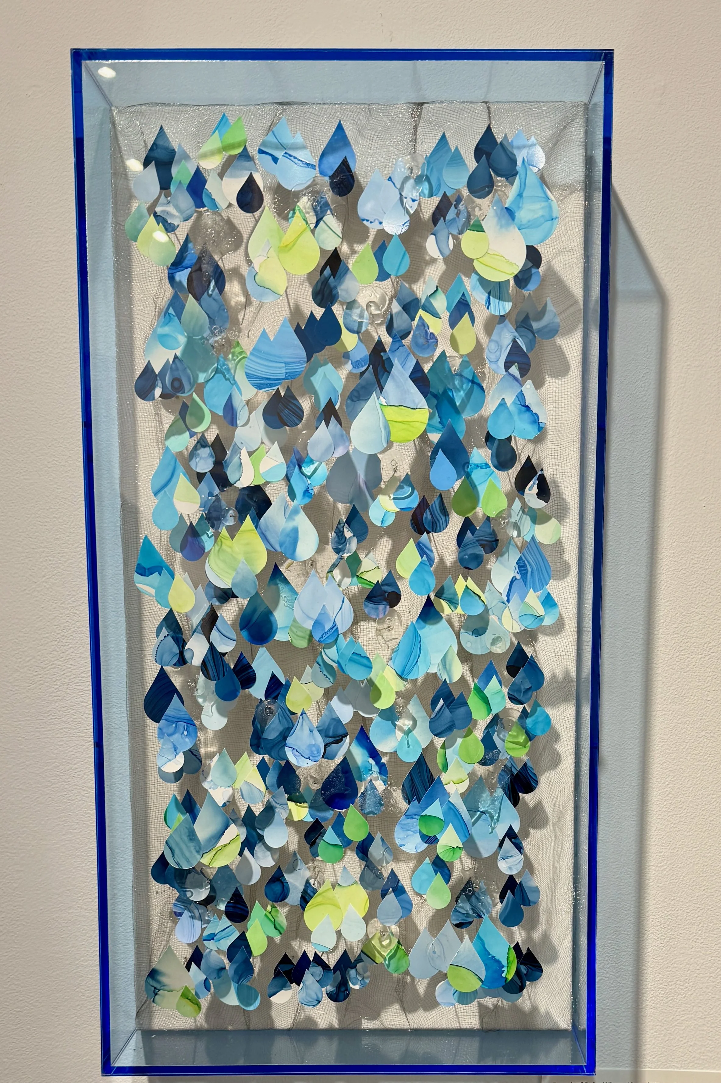Framed in a custom plexiglass 24X 12x 4.5" shadow box frame,  "Breath of Rain: Where And Water Meet in Renewal"  is layered and attentive, guided by close observation and playful material exploration. I imagine how rainfall moves through the air, how