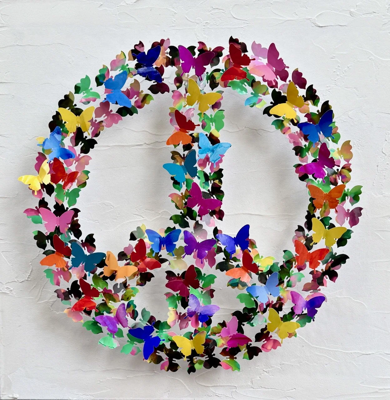 Among the Wild Flowers is created from hand cut paper butterflies that compose the iconic peace sign. As sunlight moves across the artwork, shadows of wings dance. The butterflies seem ready to take flight again at any moment. 20x20x3" ready to hang 
