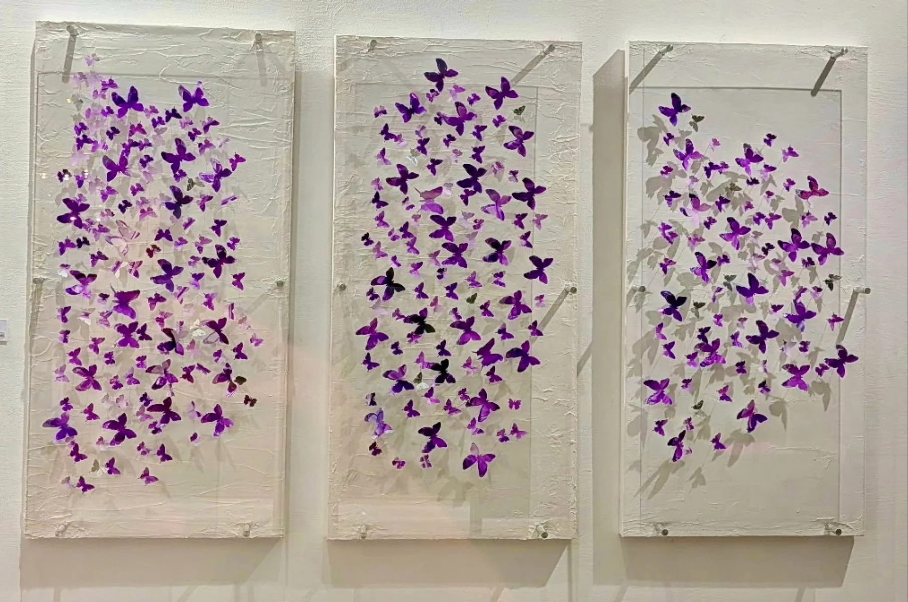 "Suspended Transformation" This triptych captures a moment of quiet metamorphosis as hundreds of hand-cut butterflies drift across three interconnected panels, suggesting movement that extends beyond the boundaries of each individual work. Layers of 