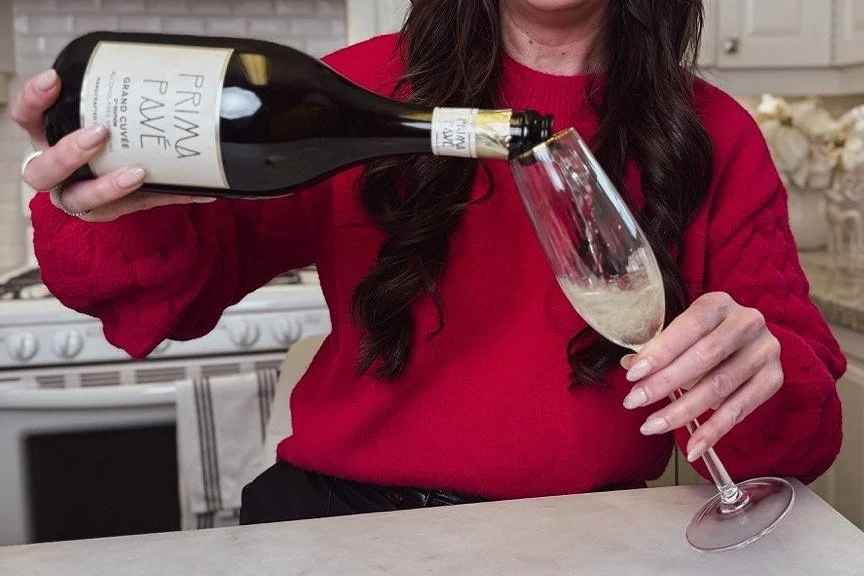 Sarah Kate pours alcohol-free wine Prima Pave into a champagne flute