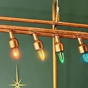 String of colorful string lights hanging against a green background.