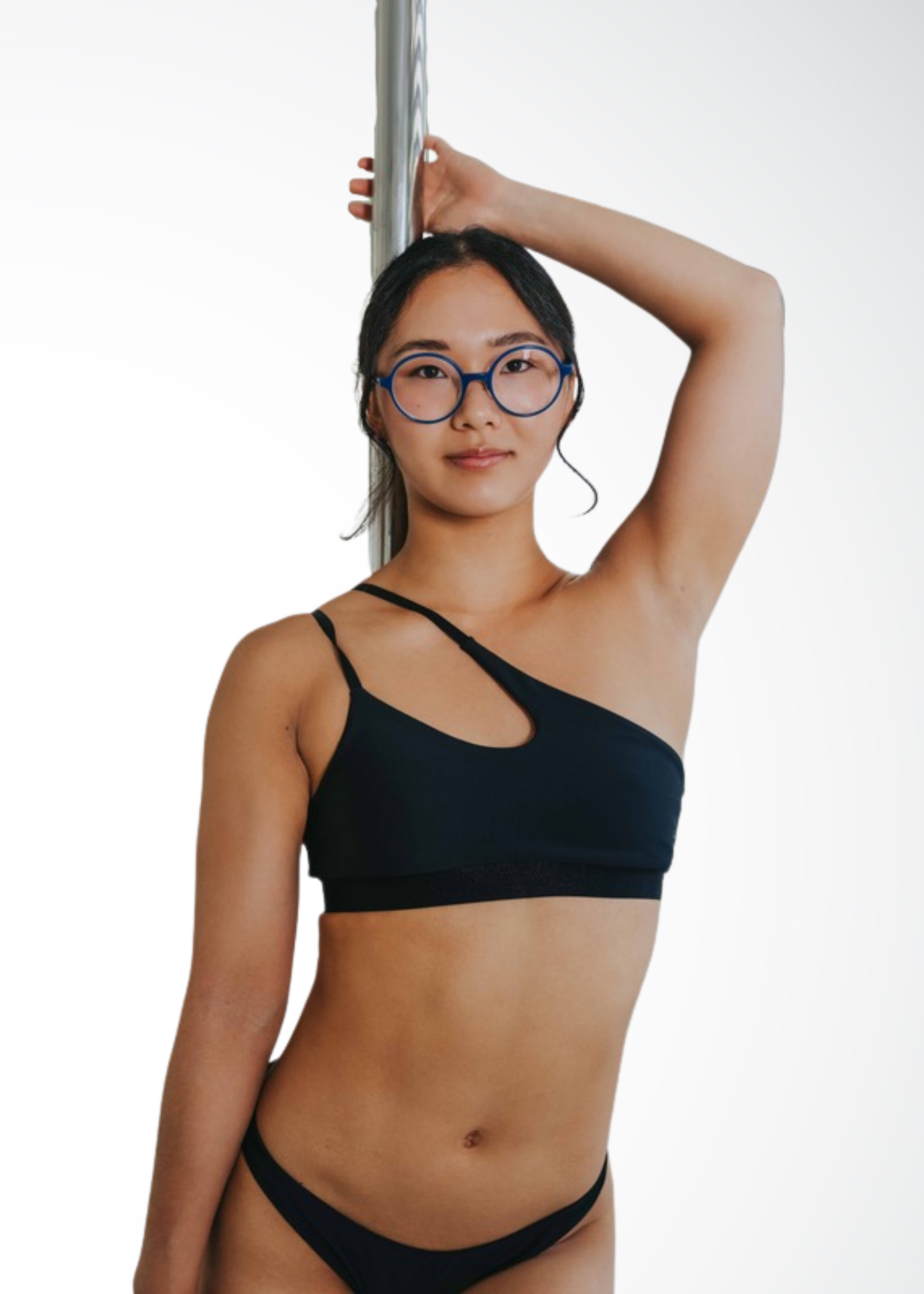 Kana, pole and flexibility instructor at Full Circle Harlem, demonstrating controlled pole movement in NYC