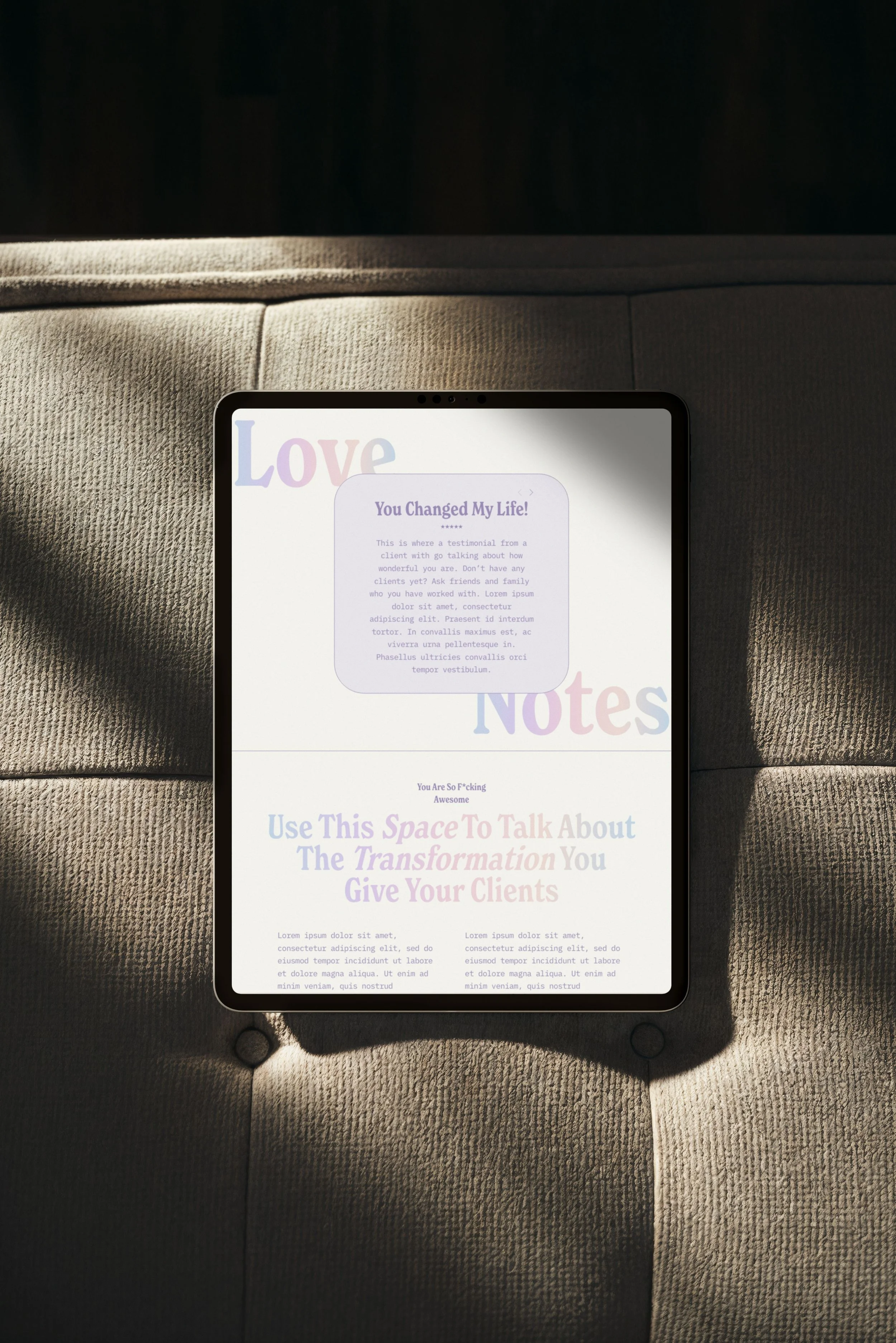 A tablet with a gradient font website template for coaches and therapists sits on a couch in sunlight