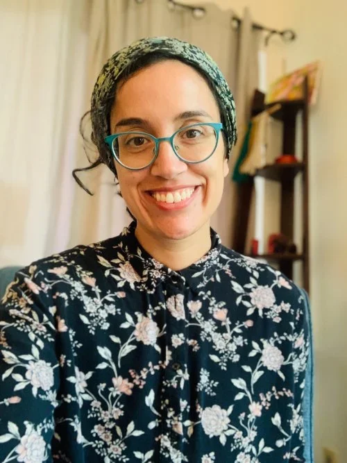Smilin woman wearing a headscarf and flowery shirt 