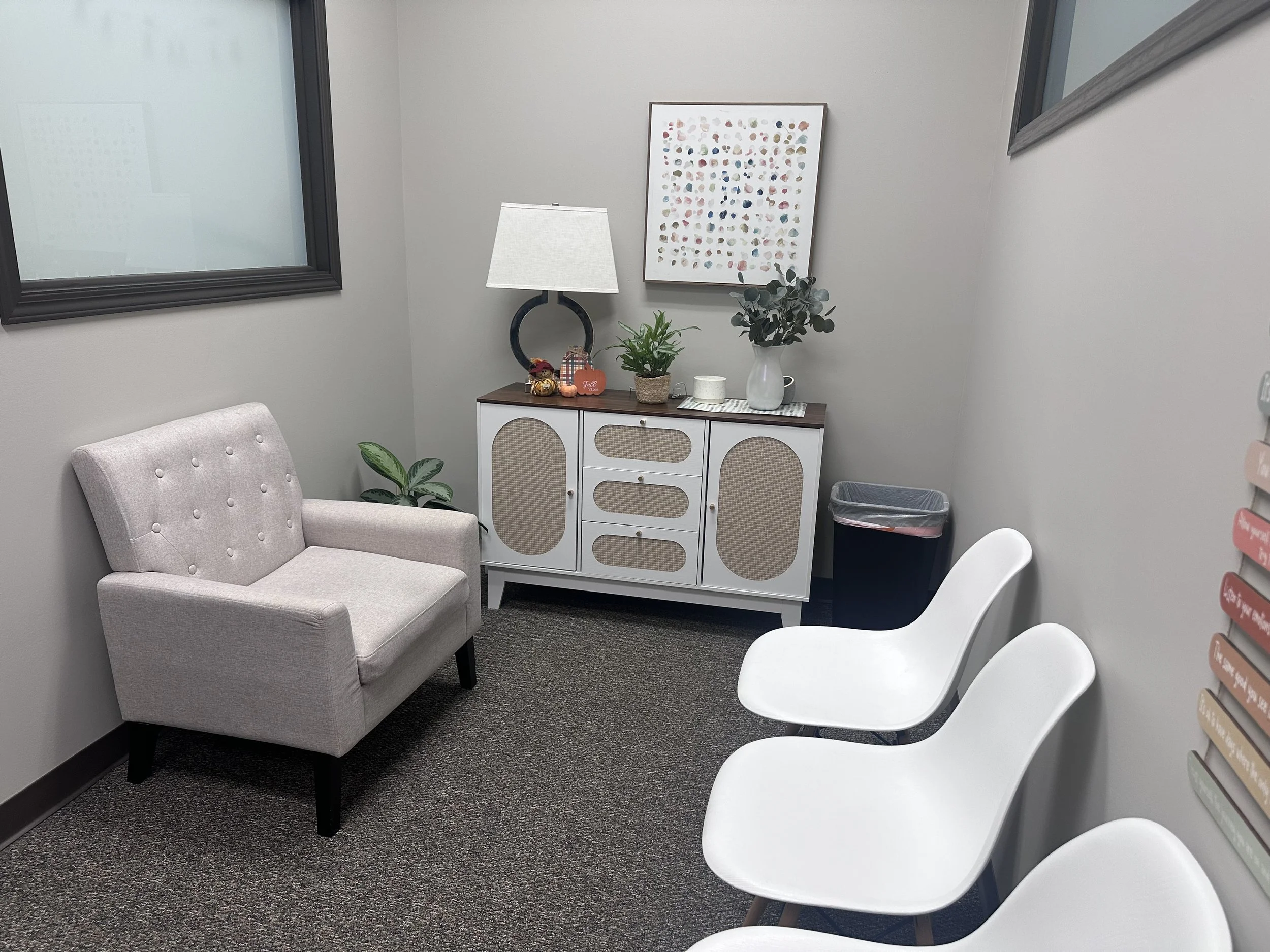 soothing lobby setting with soft and hard chairs, green plant, lamp