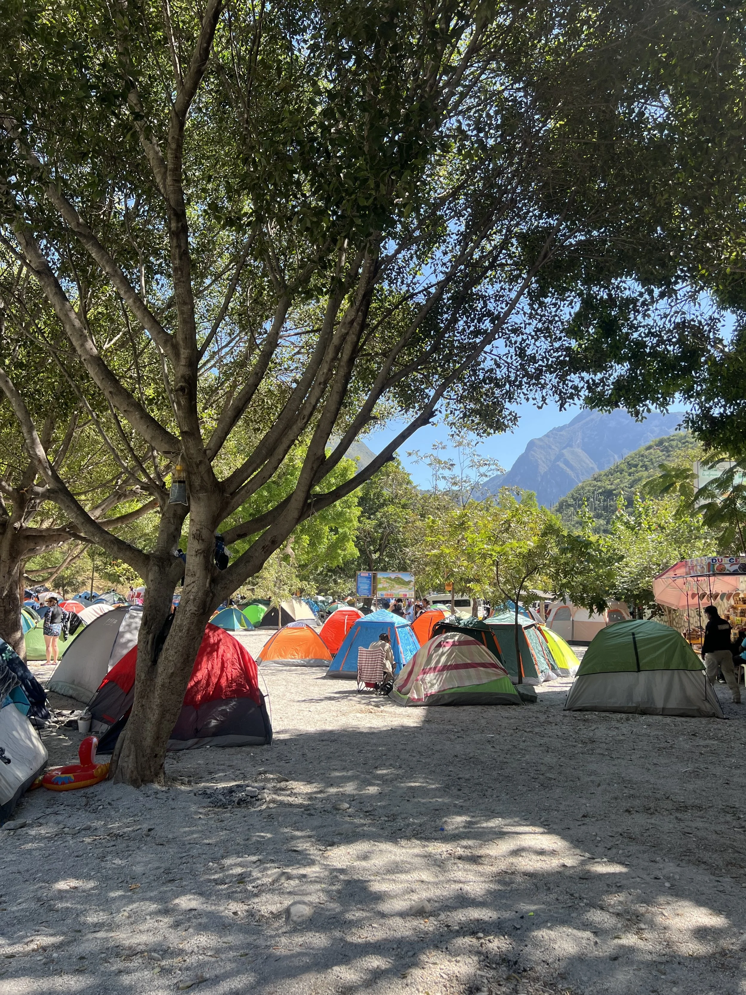 several colorful tents by a river