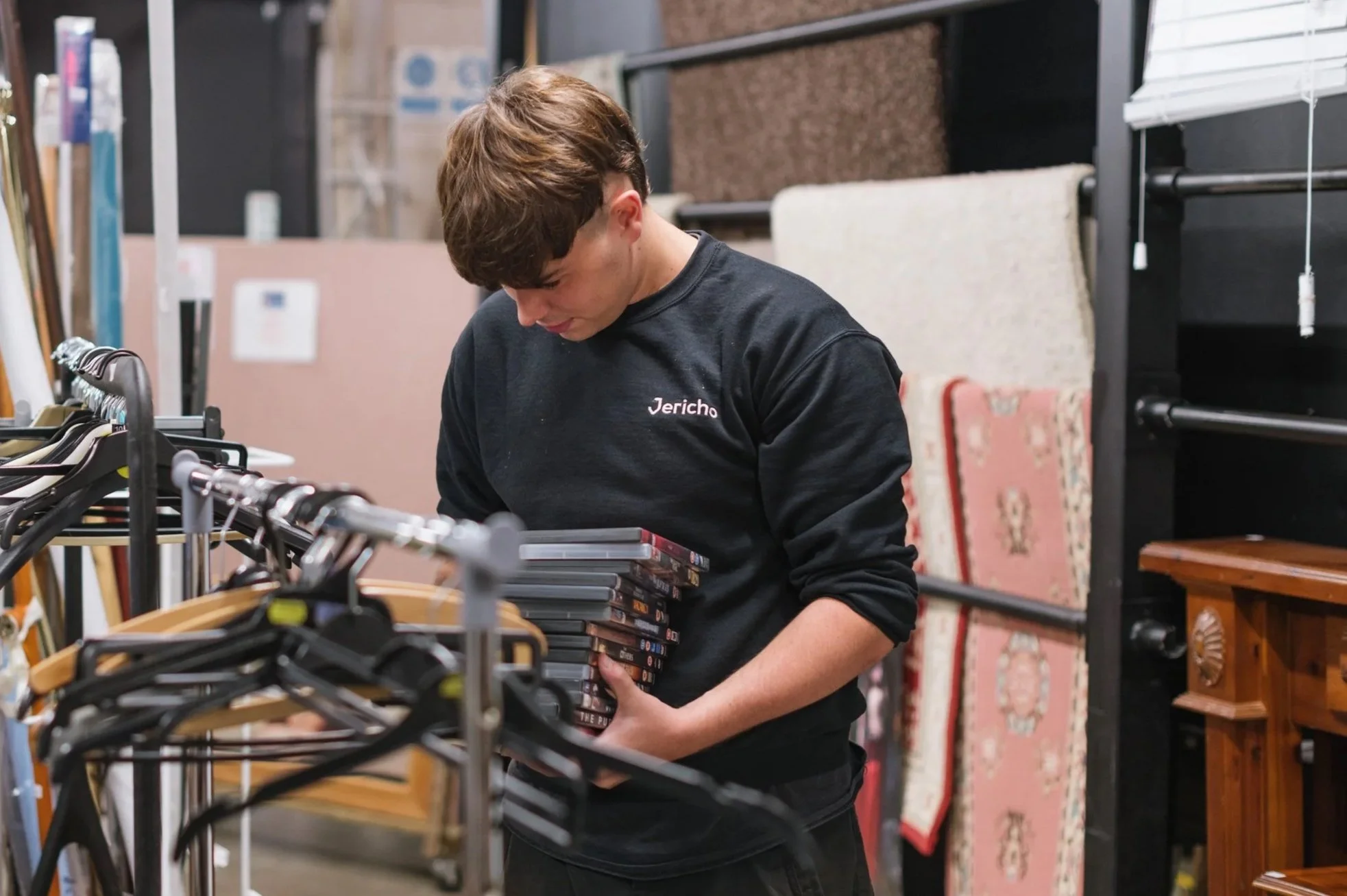 Man carrying a stack of DVDs
