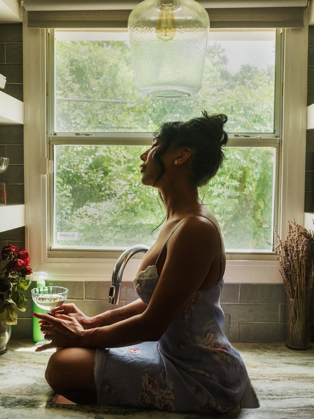 Woman seated by a window in soft light