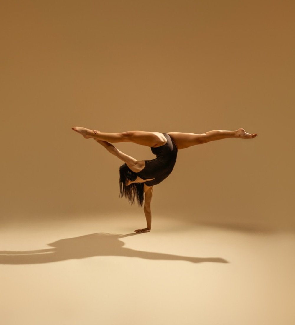 Dancer in a one-handed split handstand