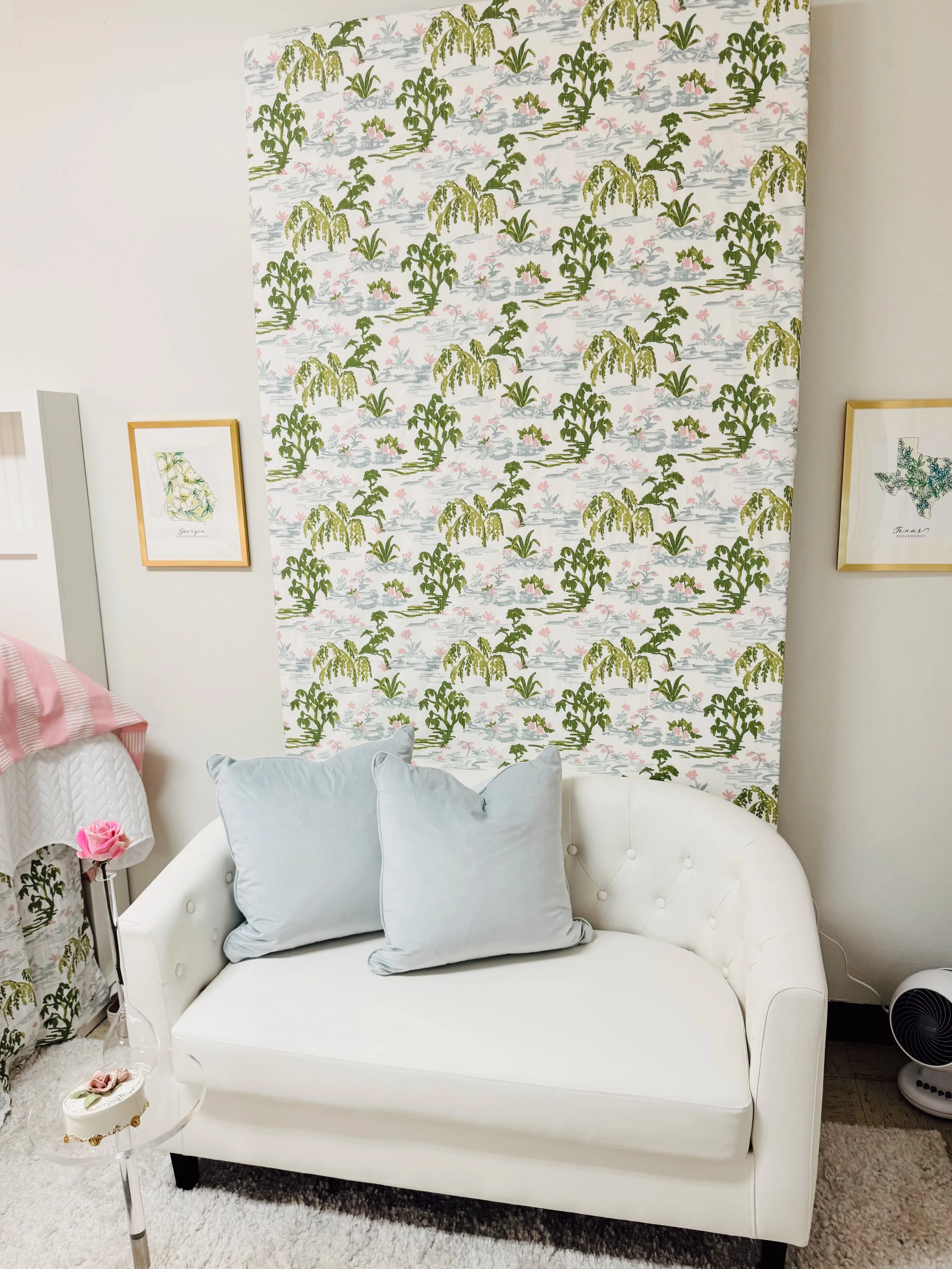 Tropical dorm design with palm print wallpaper and white couch seating
