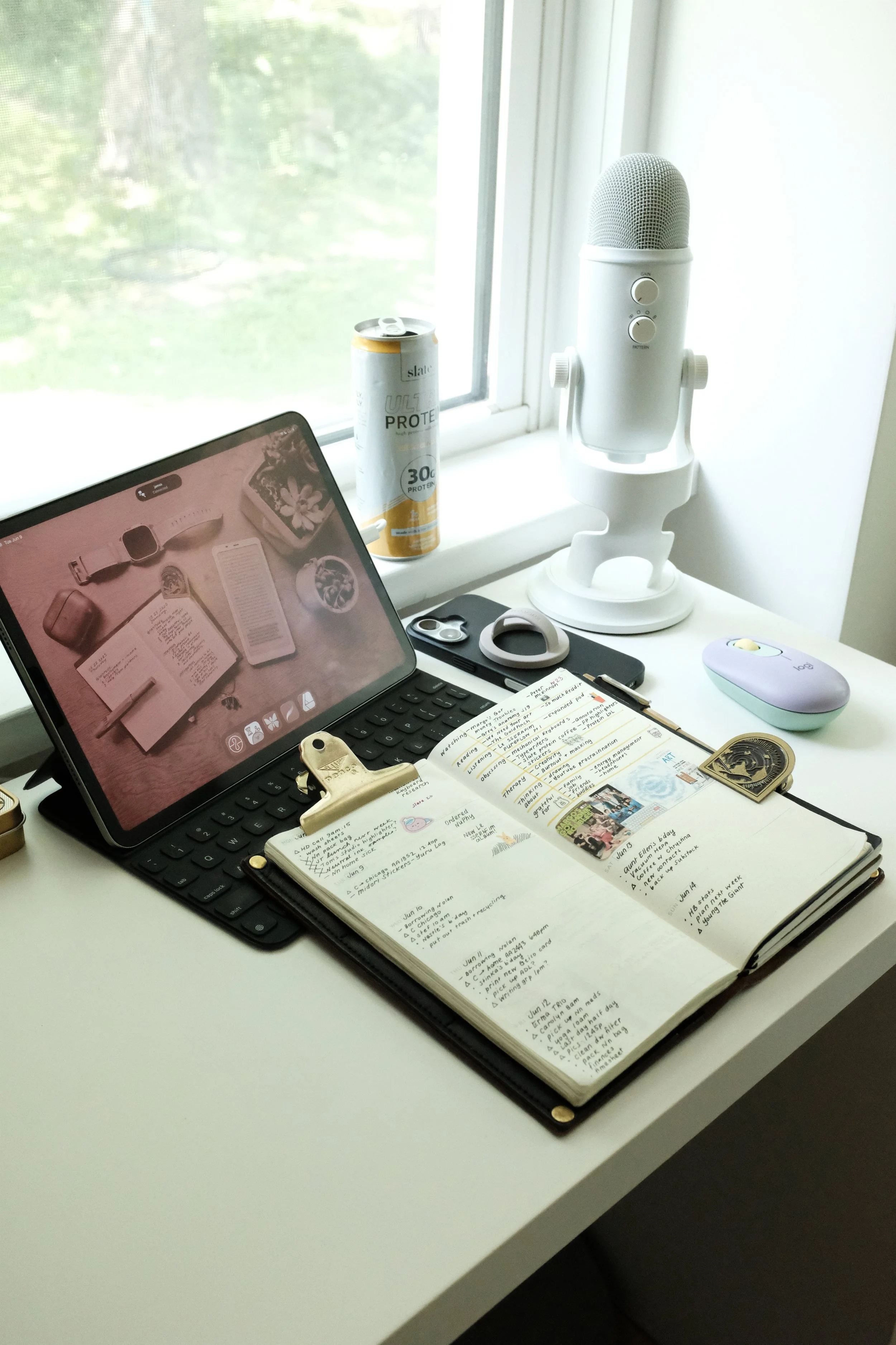 Traveler’s Notebook planner sitting on desk with iPad and phone