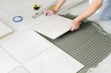 Professional tiler installing 18"x 18" tilie