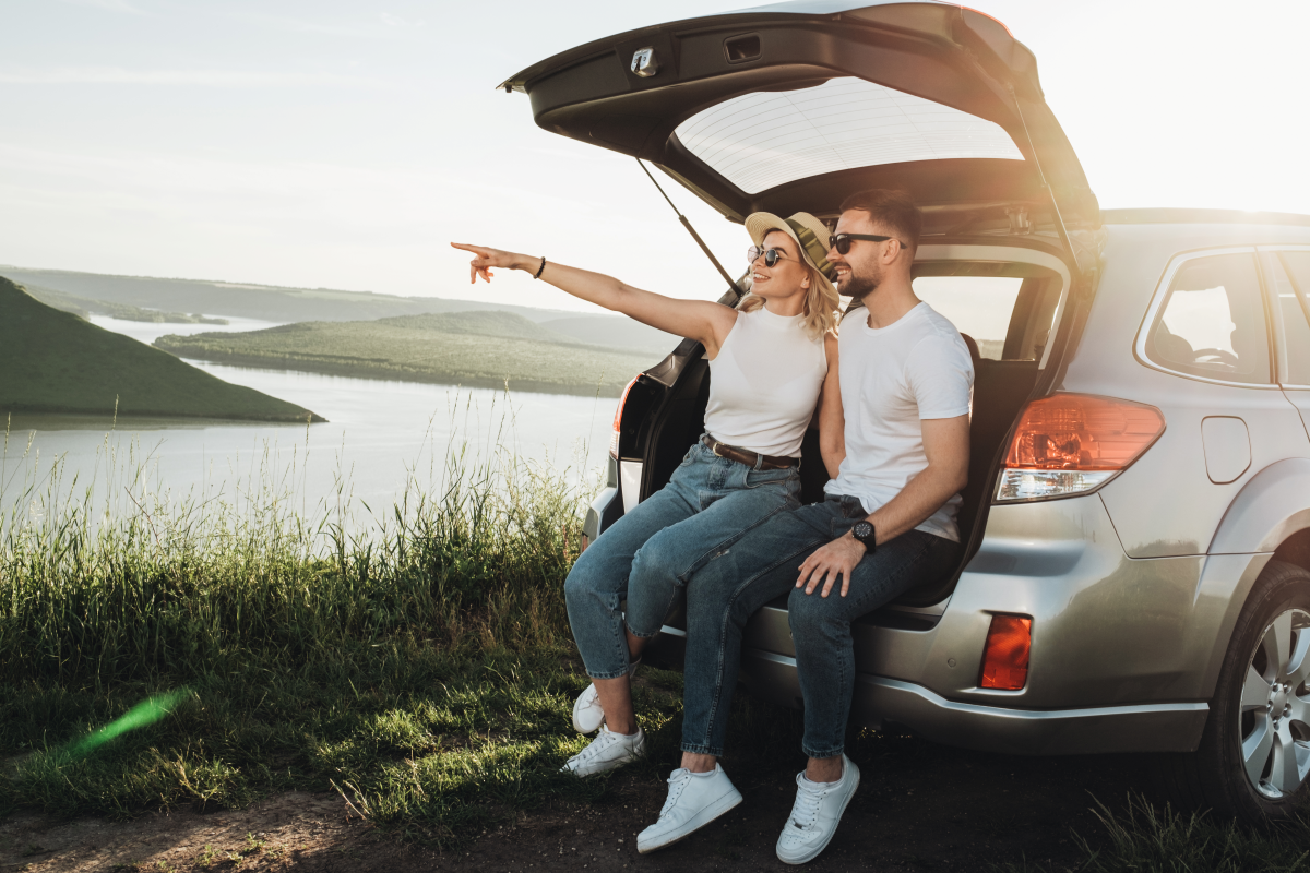 Young couple sitting in back of SUV