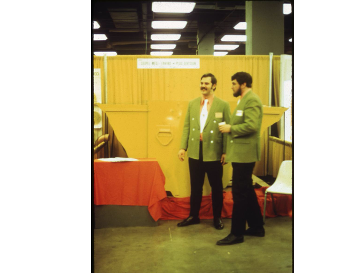 Vice President and Fiscal Consultant, Wm. :”Bill” Rowe and President, Joseph “Joe” Seipel at the booth in “Seipel” business attire.