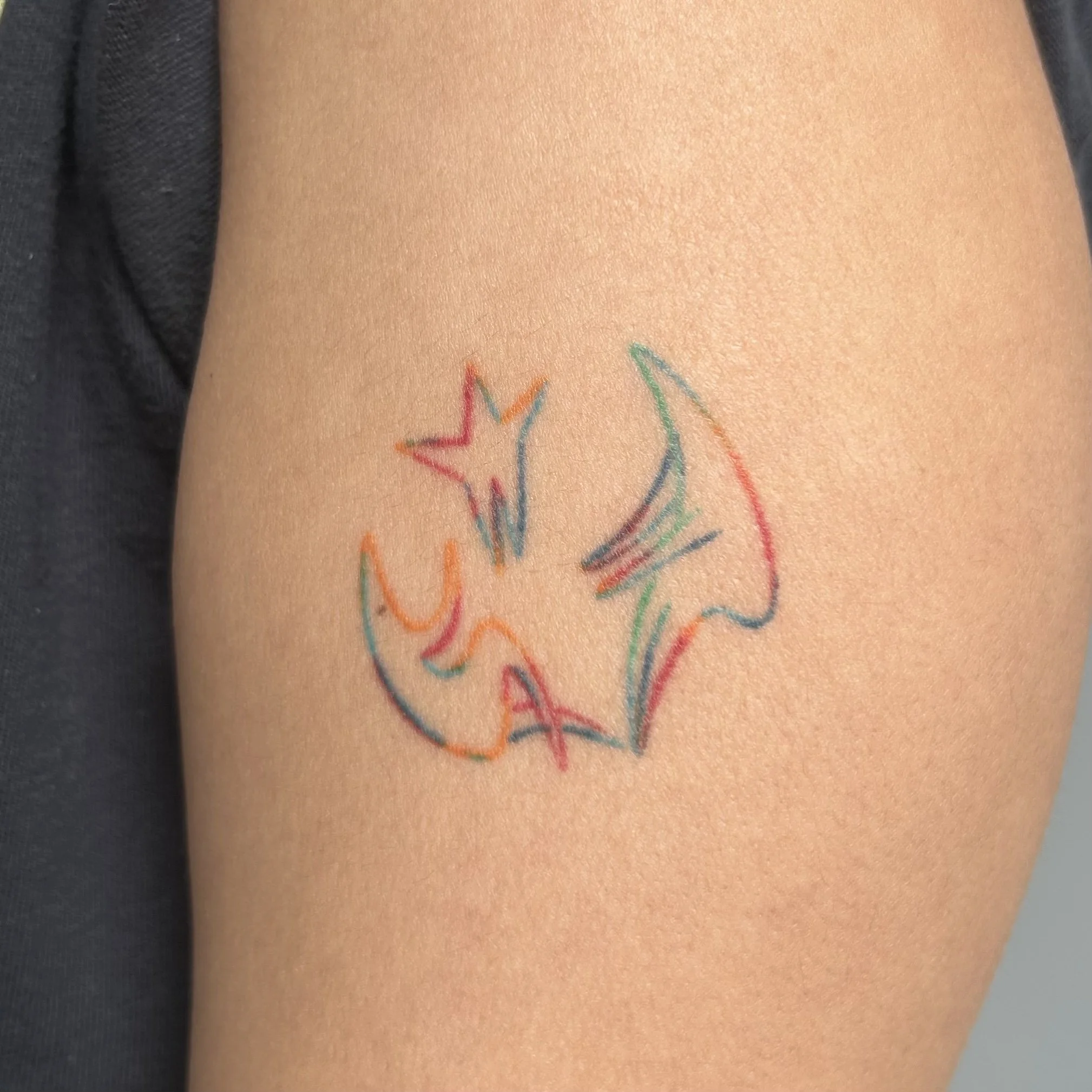 Colorful tattoo of abstract people holding a star on the arm