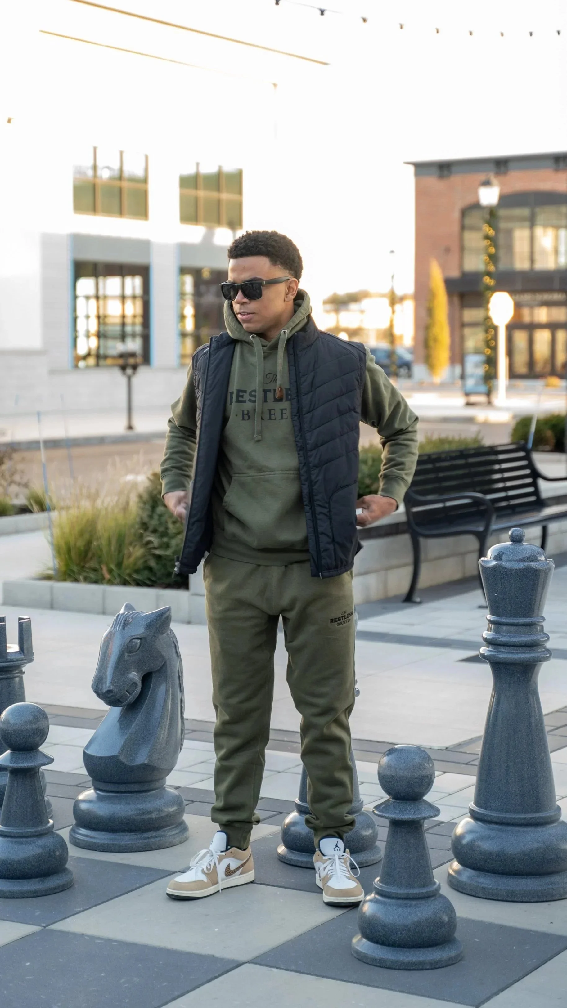 Man wearing matching mikitary green restless breed hoodie and joggers in Tuscan Village Salem, NH