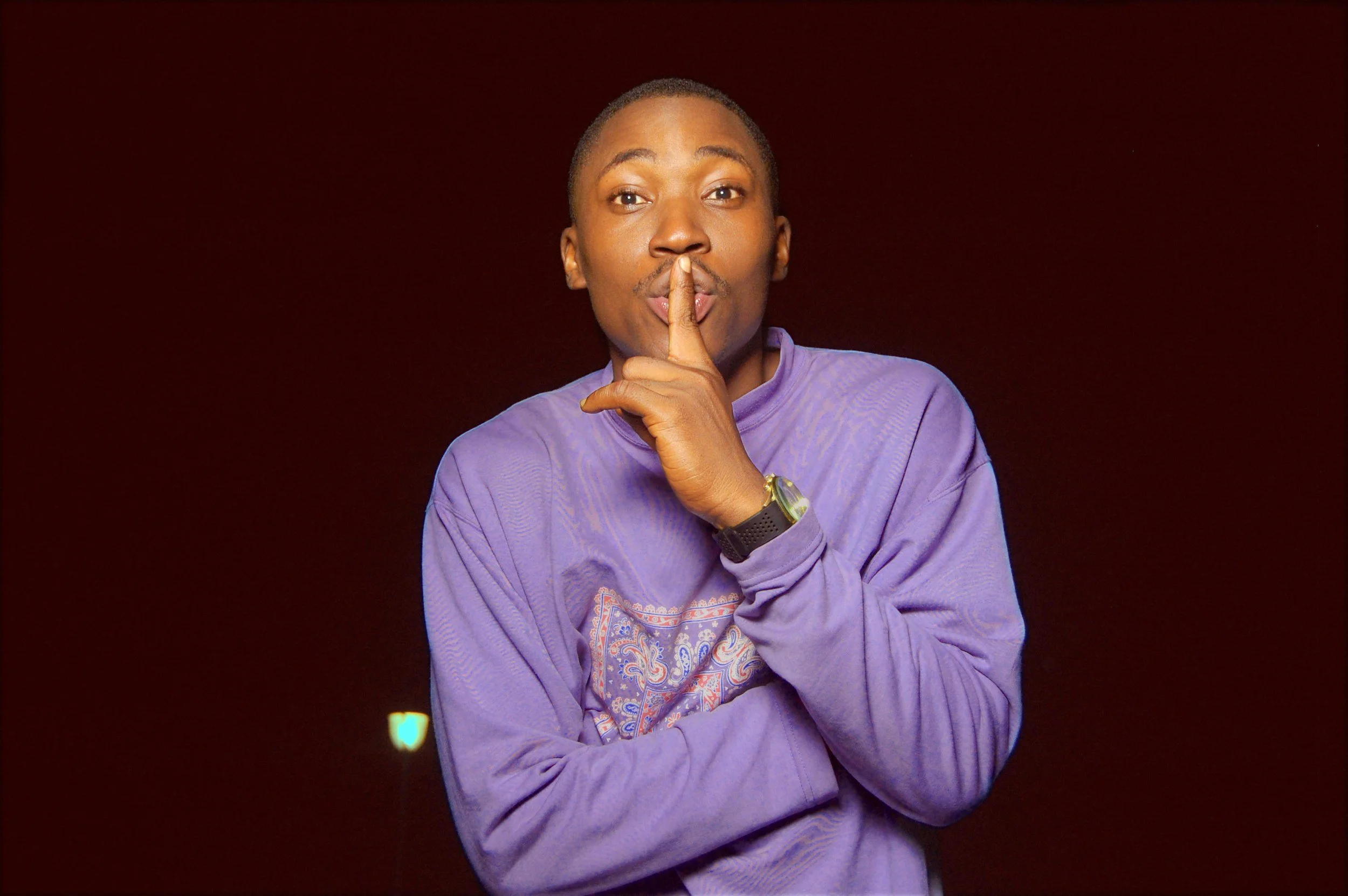 a person doin g the "shhh" signal with his finger on his lips