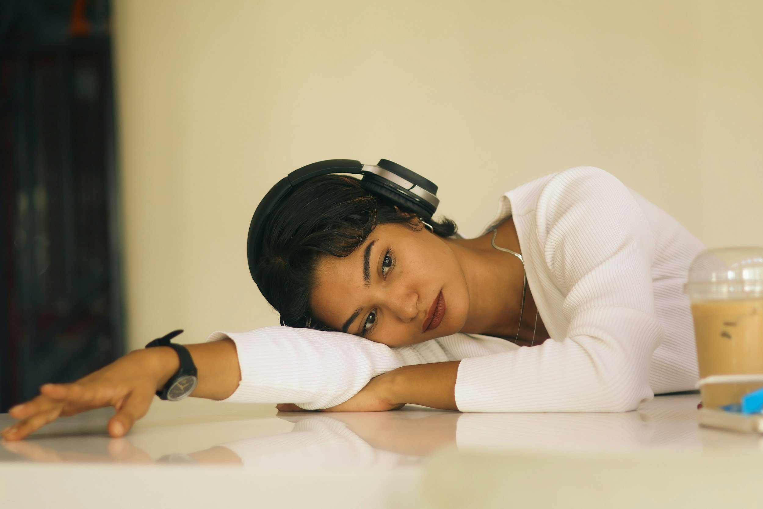 a person wearing headphones resting on their arm out of boredom