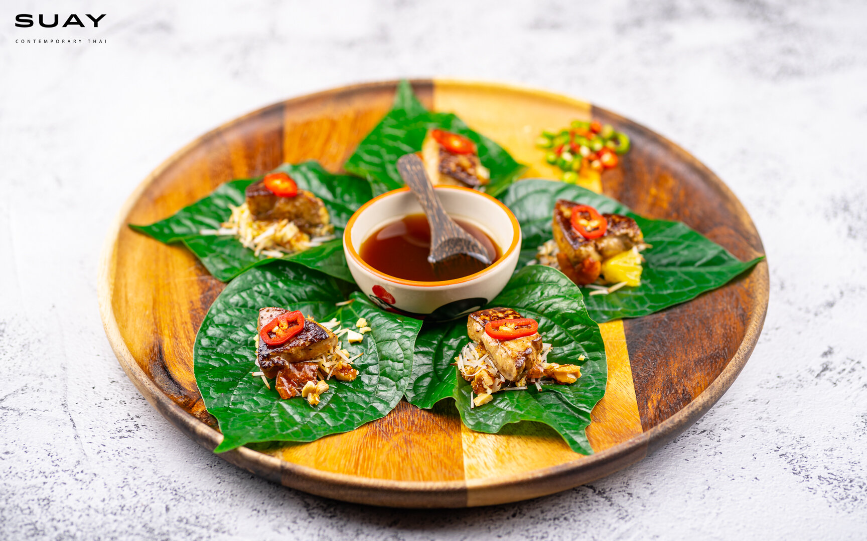 Foie gras in betel leaf wrap, ginger, cashew nuts candy with sweet and sour dip.
