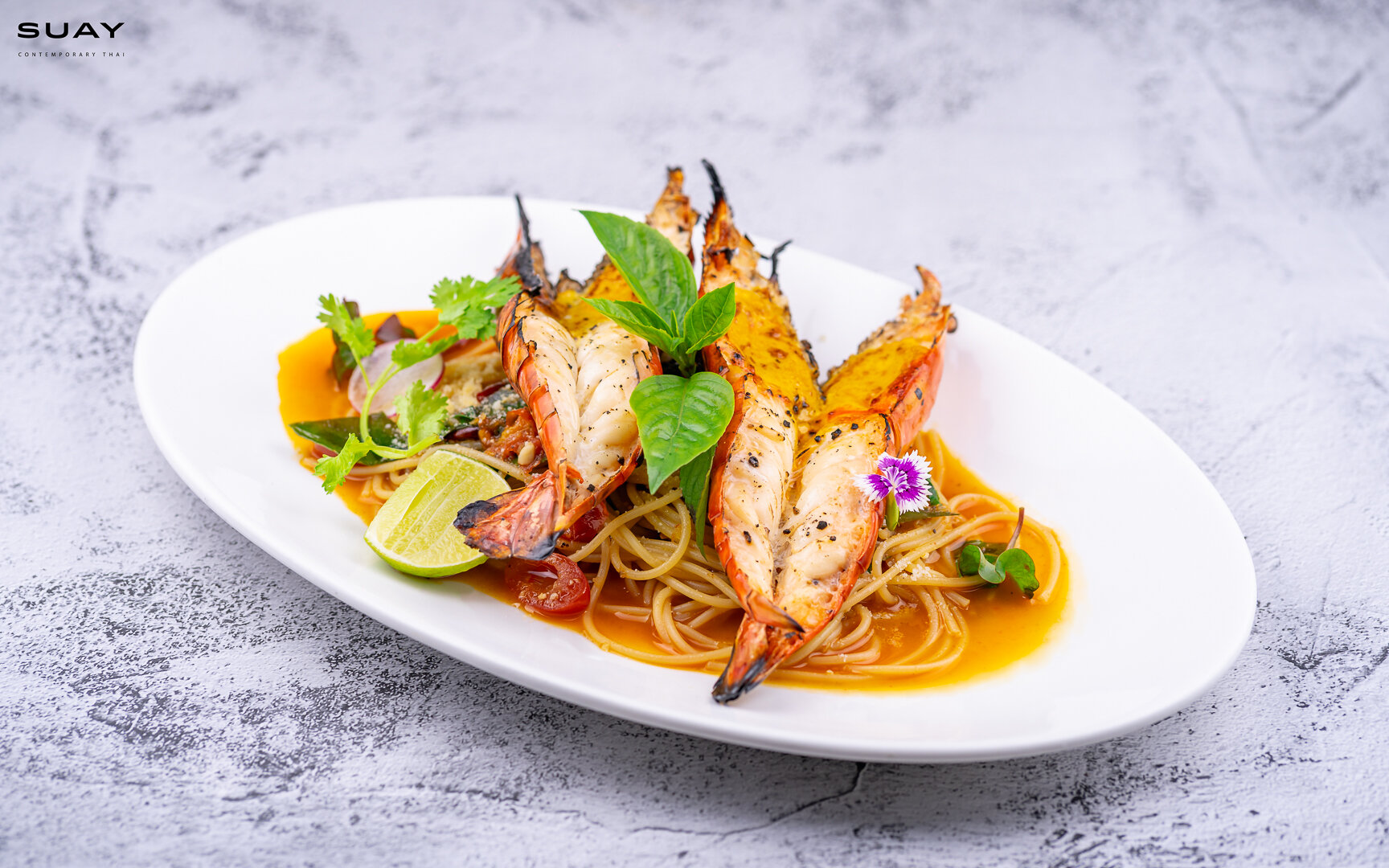 Spaghetti with signature recipe tom yum butter and grilled giant river prawns.