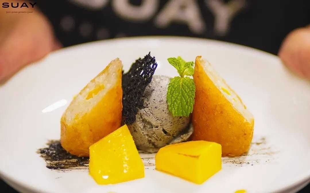 Mango sticky rice spring roll with flamed mango and black sesame ice cream