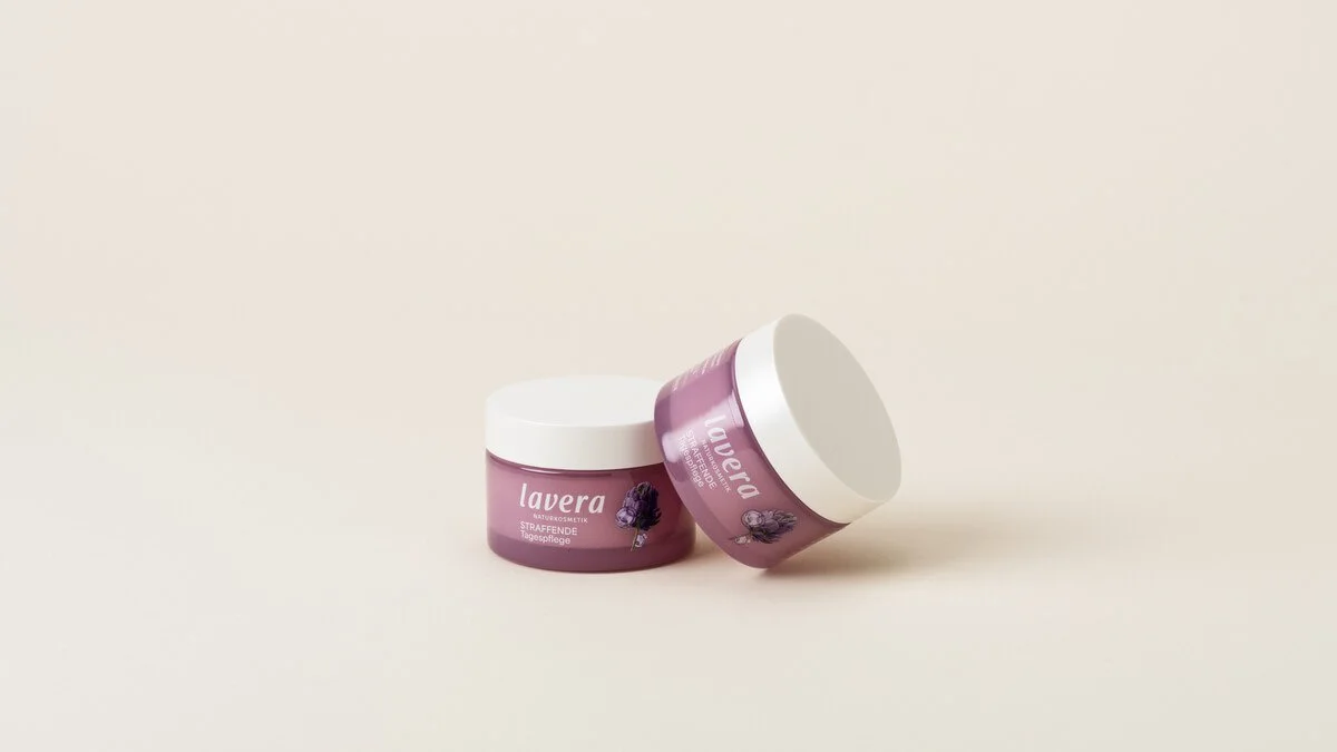 Two jars of lavera Firming Day Cream, one on top of the other, on a plain beige background.
