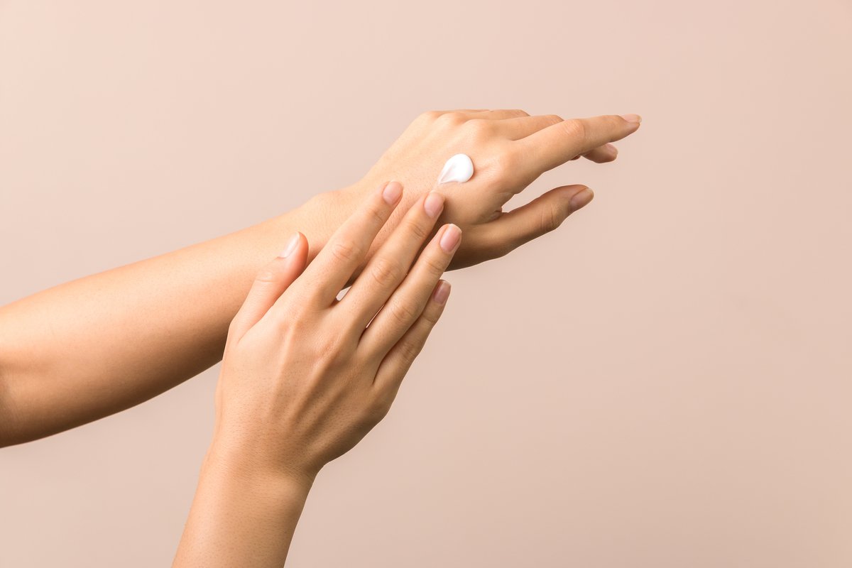 A person applying hand cream to their hand.