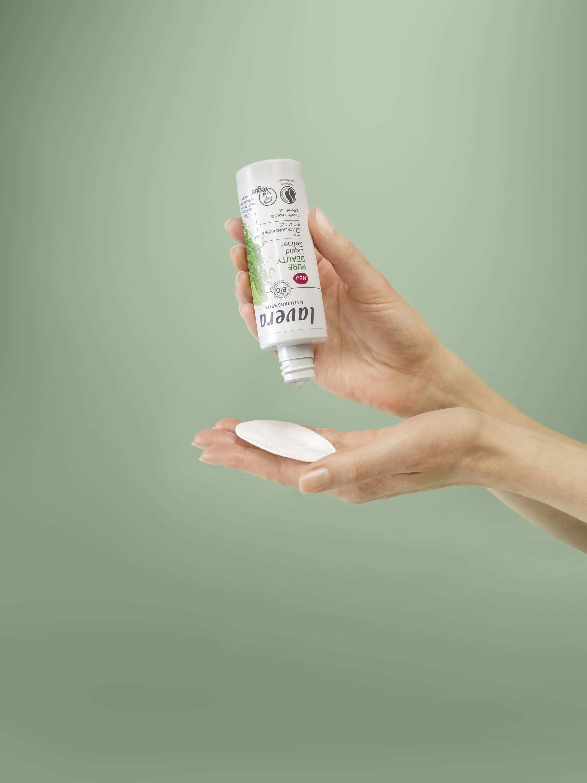 Hand holding a lavera Pure Beauty Liquid Refiner.