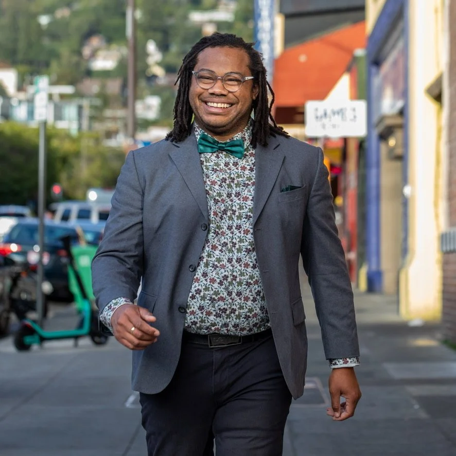 Aidan Hill walking on Durant Avenue in Berkeley’s Southside, smiling while visiting local businesses during their District 7 City Council campaign.