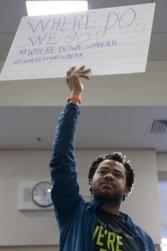 Aidan Hill holding a sign that reads "Where Do We Go?"