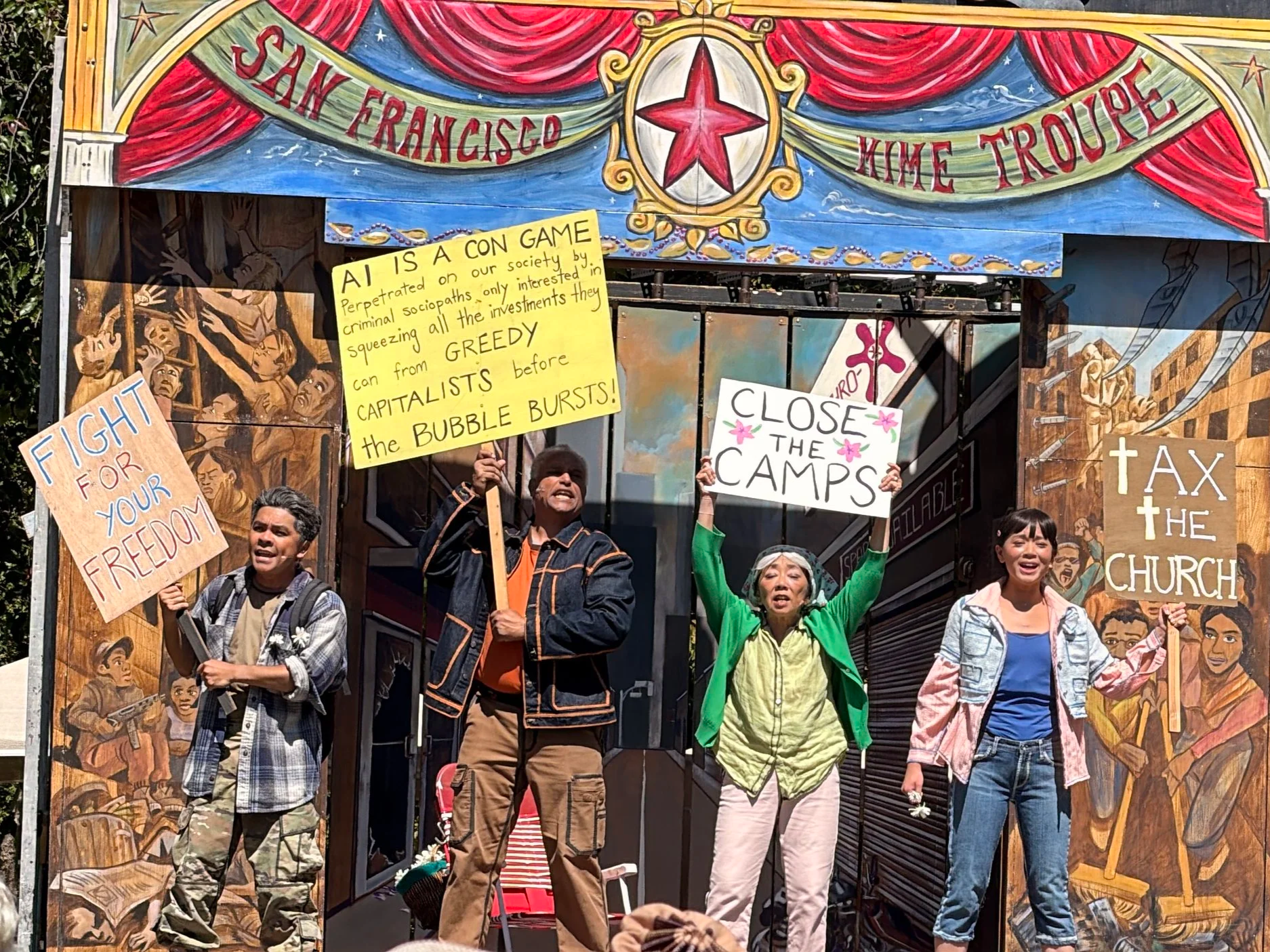 Four actors performing WRECKAGE on the San Francisco Mime Troupe's painted outdoor stage at Live Oak Park