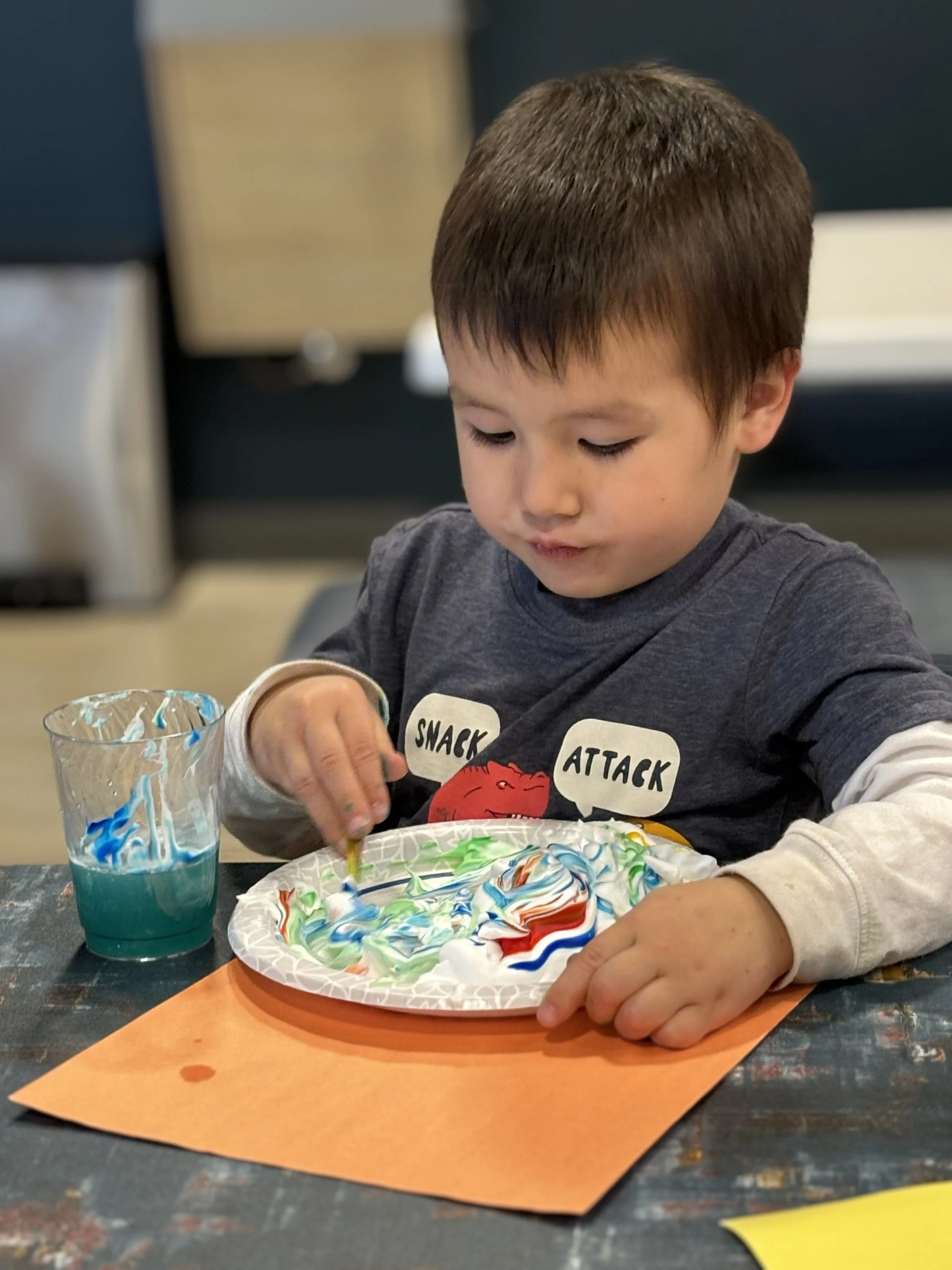 This camper is making a marble art painting with food dye and shaving cream! Each themed craft and activity is based on that week's theme, changing daily.