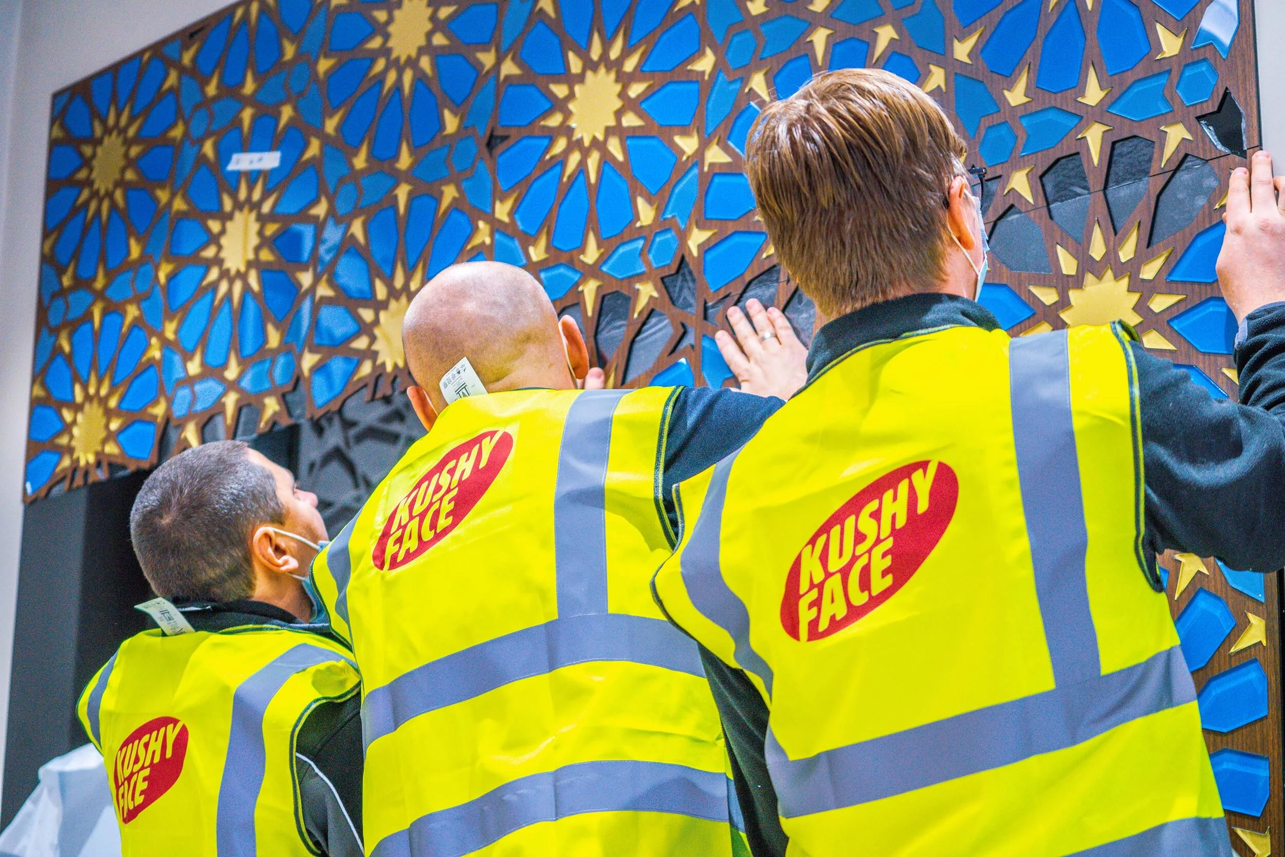 team members installing mosaic piece 