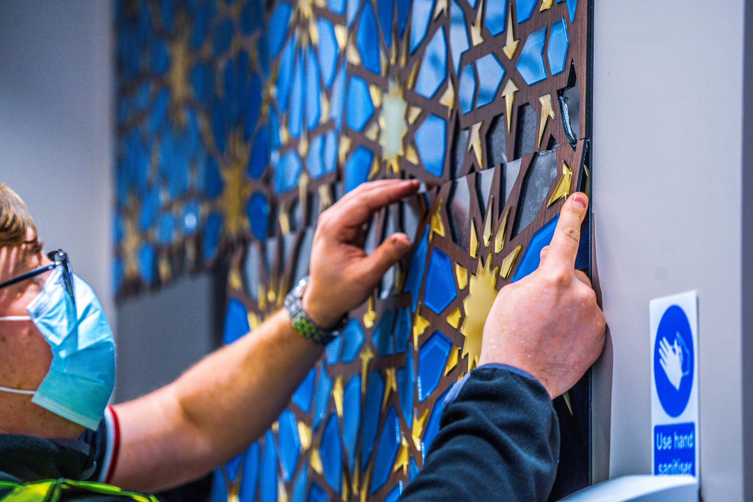 team members installing mosaic piece 