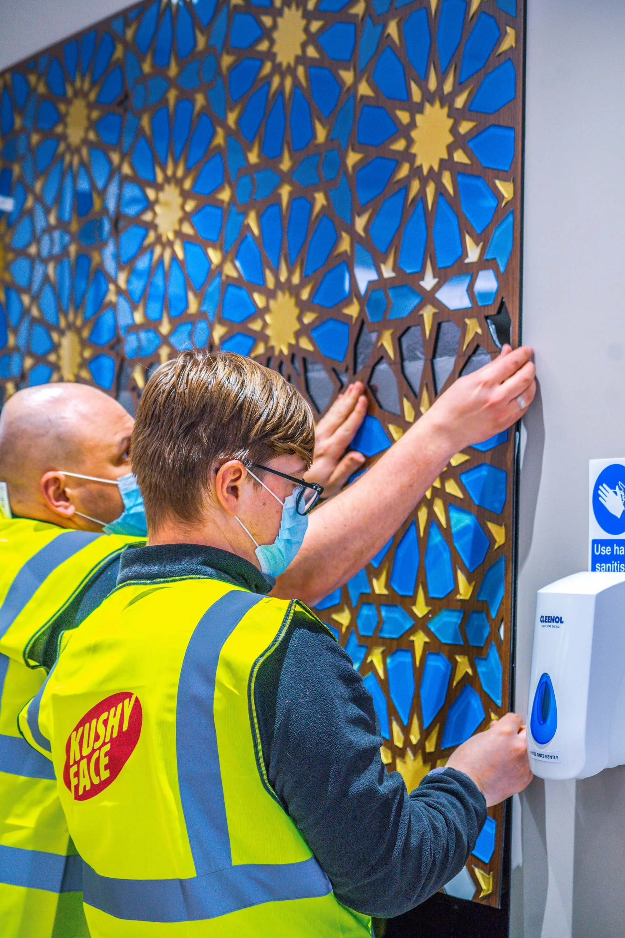 team members installing mosaic piece 