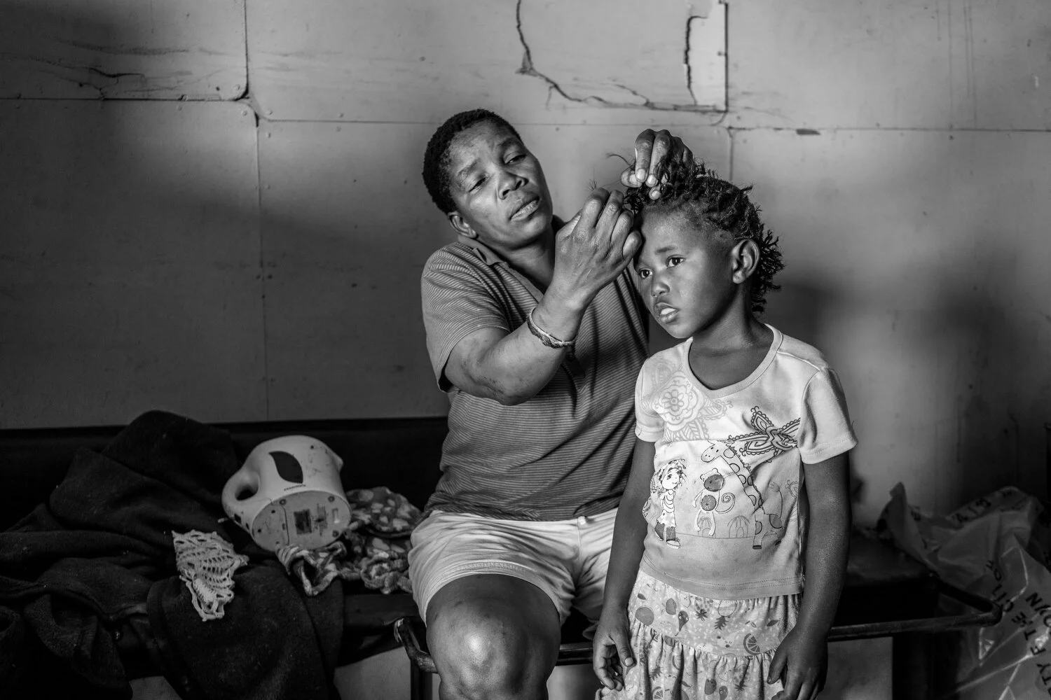  Khayelitsha, Cape Town, South Africa - 08/01/2019  Mzimkhu is braiding the hair of her friend’s daughter in their house in Khayelitsha. Mzimkhu is HIV positive and a TB survivor. Research shows that racial disparities rooted in structural and contex
