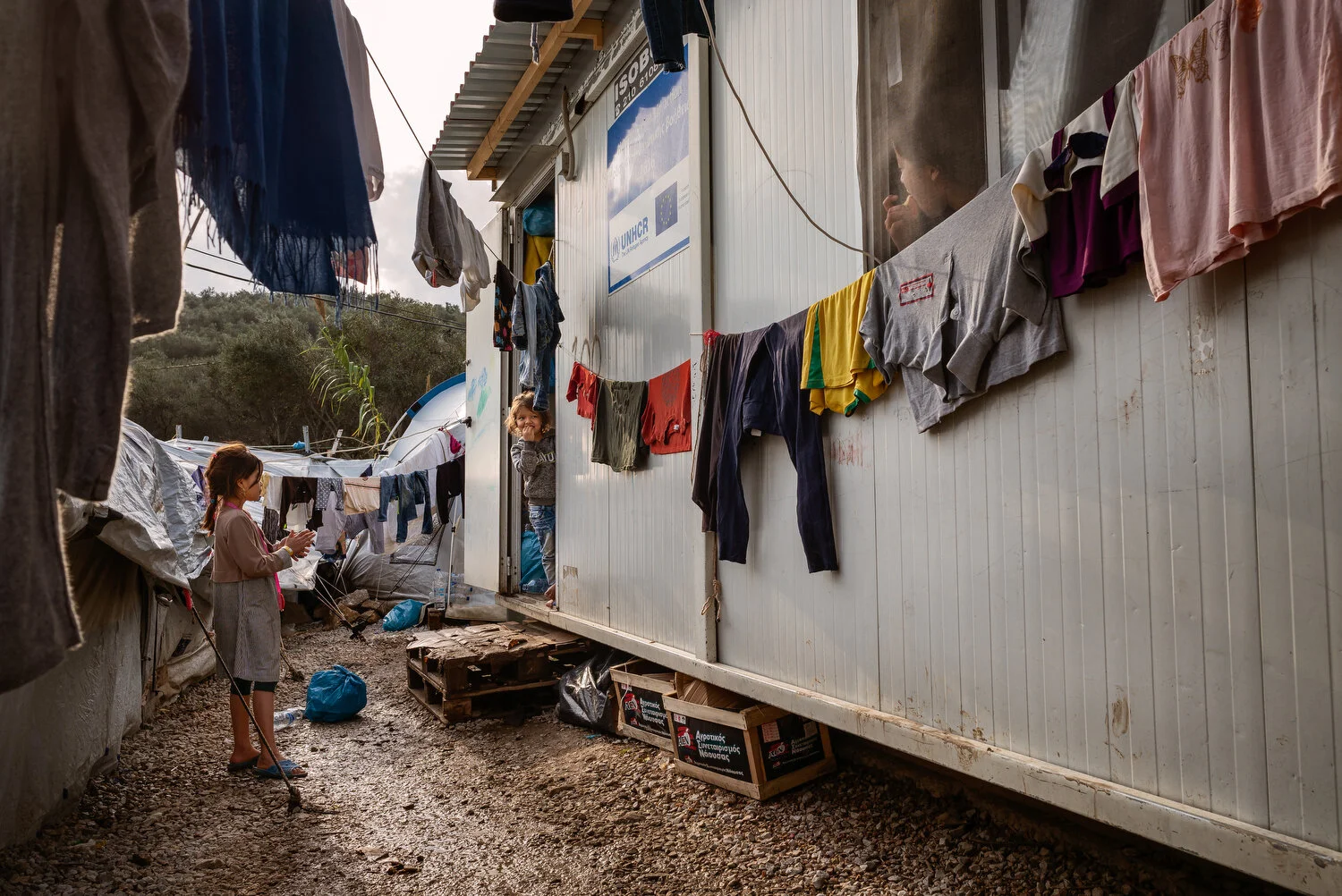  Moria Camp, Lesbos - 23/11/2019  Children playing at one of the ‘isoboxes’ inside the official parameters of the Moria camp. A container home is typically shared by two large families and divided into two compartments with a blanket for some privacy